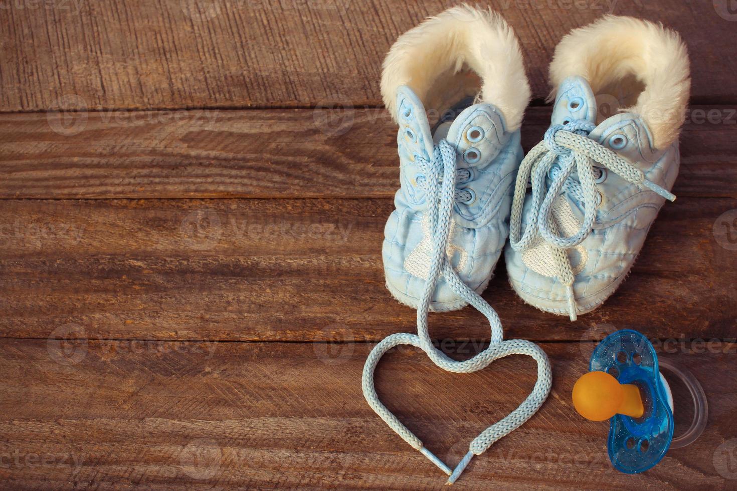 heart symbol is drawn laces of children's shoes and a pacifier photo