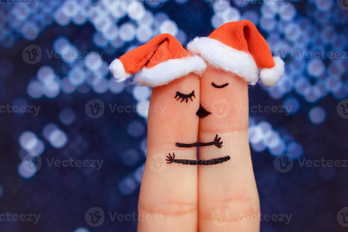 Couple kissing and hugging in the new year hats. photo