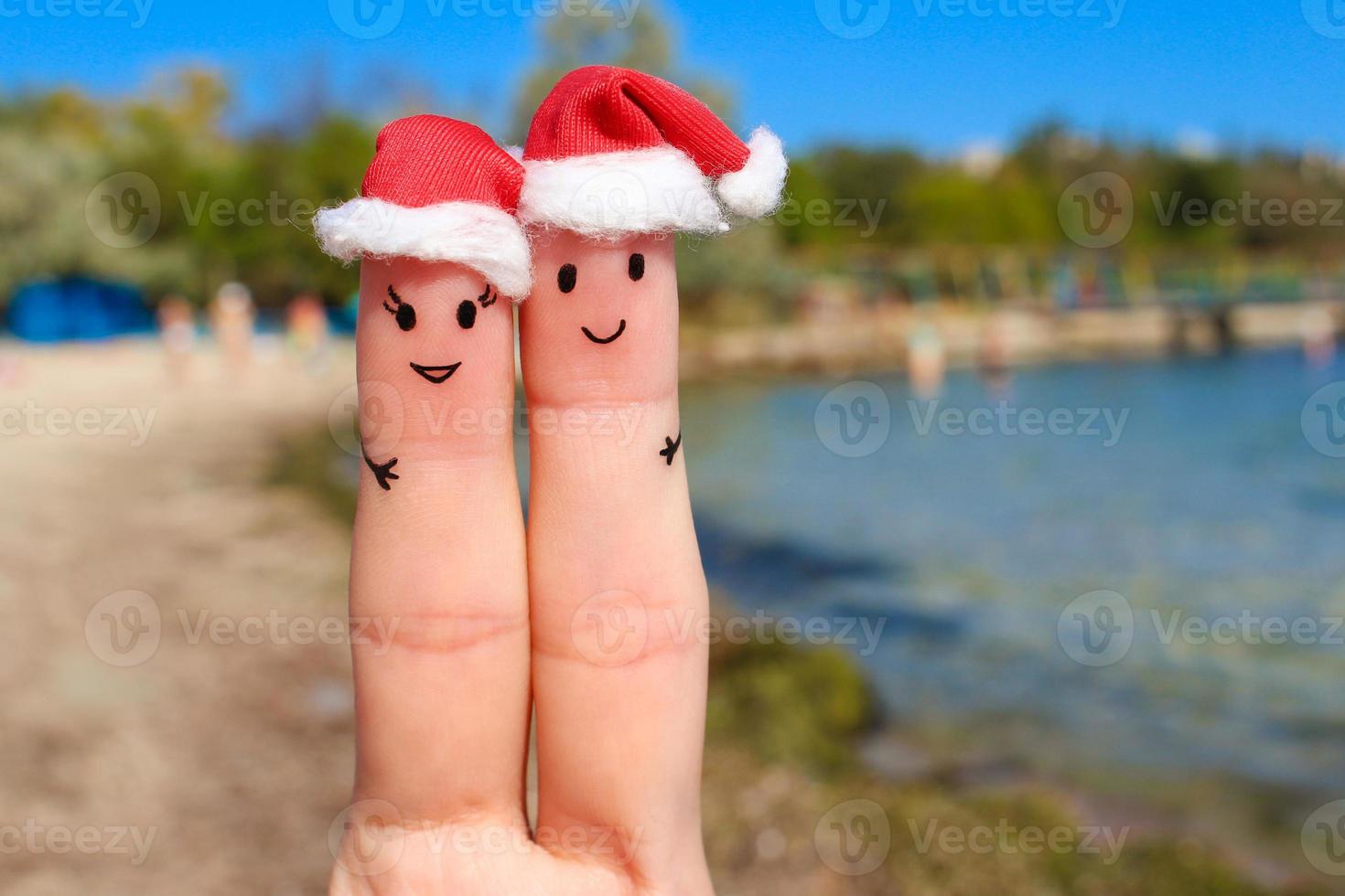 dedo Arte de un contento Pareja descansando en el mar. Pareja abrazando en el nuevo año sombreros. foto