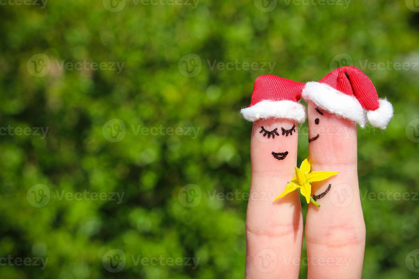 Face painted on fingers. Man is giving flowers to a woman. photo