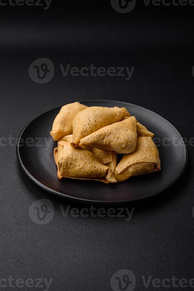 Delicious pancakes triangular shape with meat, salt and spices photo