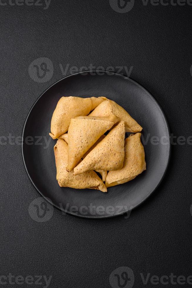 Delicious pancakes triangular shape with meat, salt and spices photo