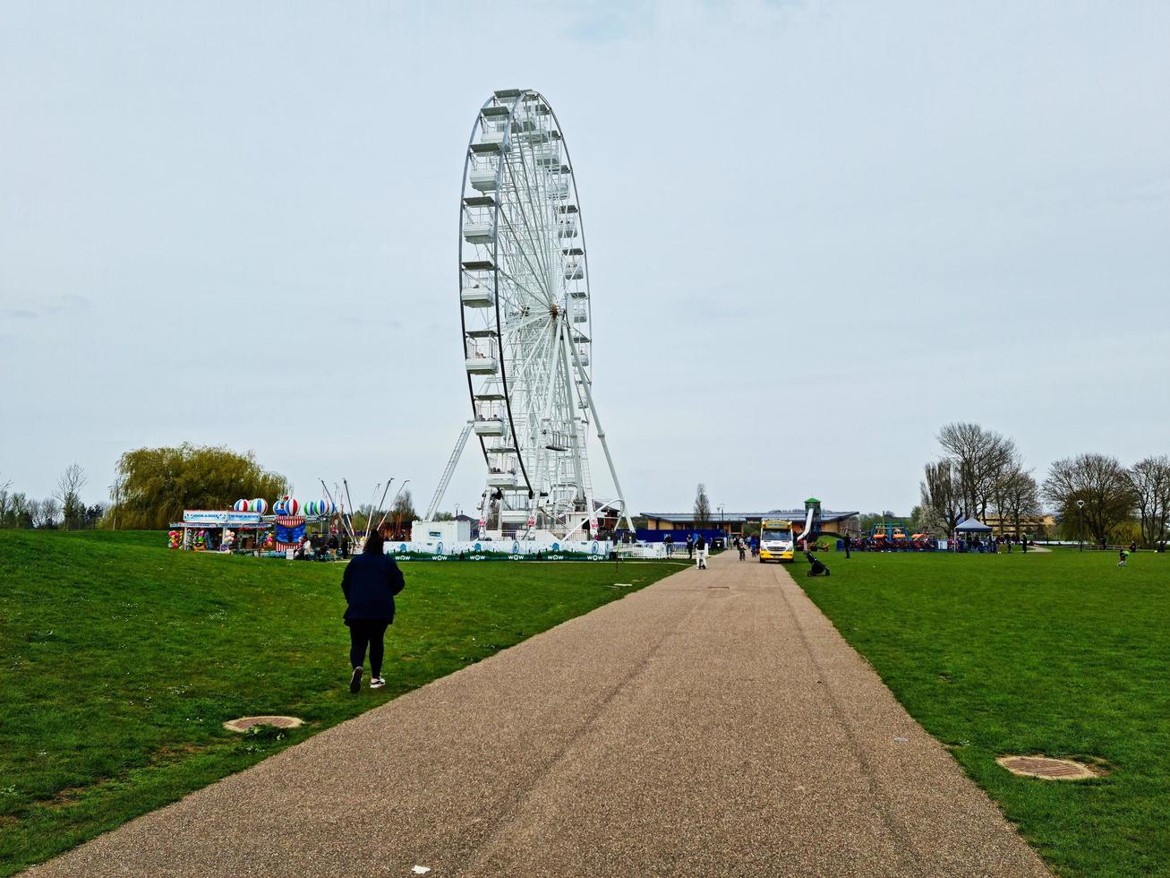 Low Angle View of Willen Lake and Public Park with Ferris Wheel for Fun. People are Enjoying the Start of Summer Season at this Park of Milton Keynes England UK. Footage was Captured on 09-April-202 photo