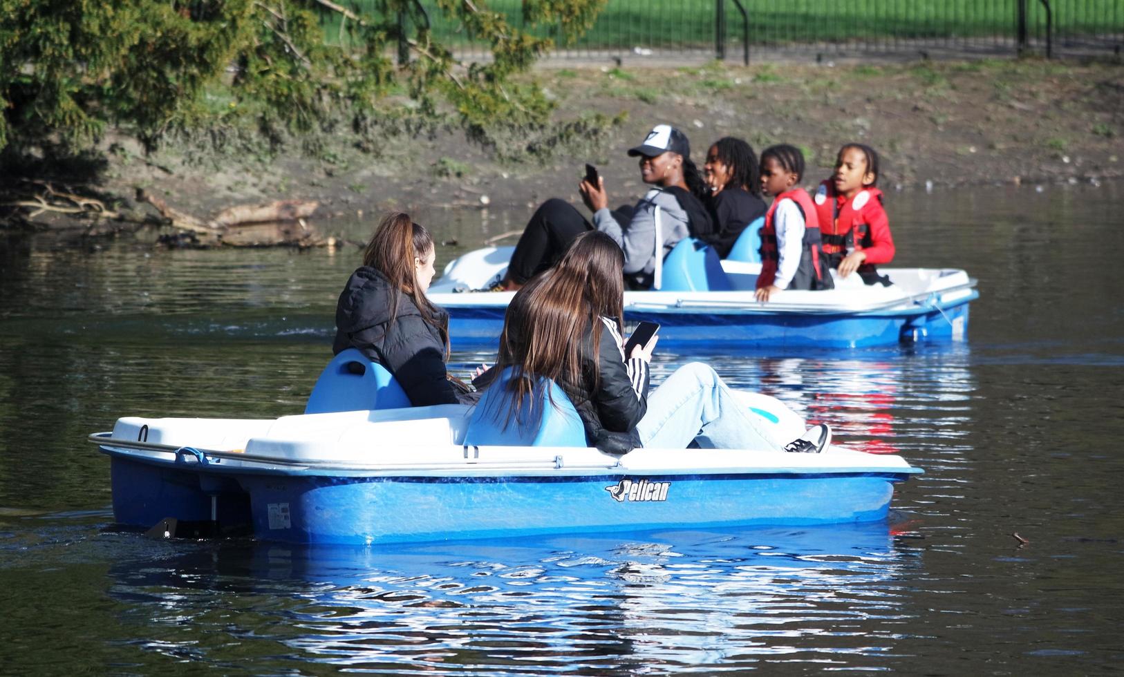 Beautiful View of People Boating a Paddle Boat at a Lake of Local Public Park of Luton England UK. Image Was Captured on 03-April-2023 photo