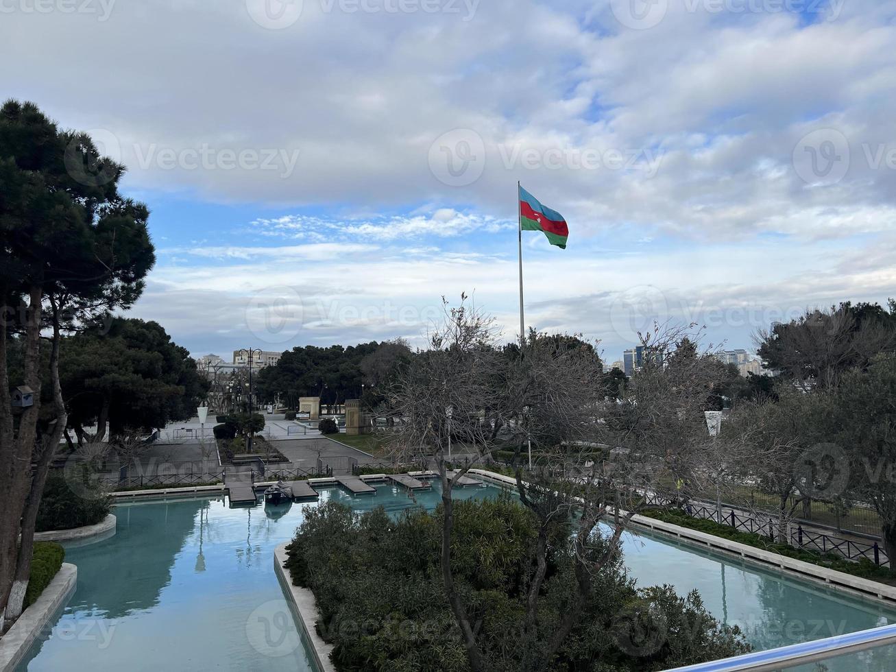 park with pool and azerbaijan flag waving in cloudy weather photo