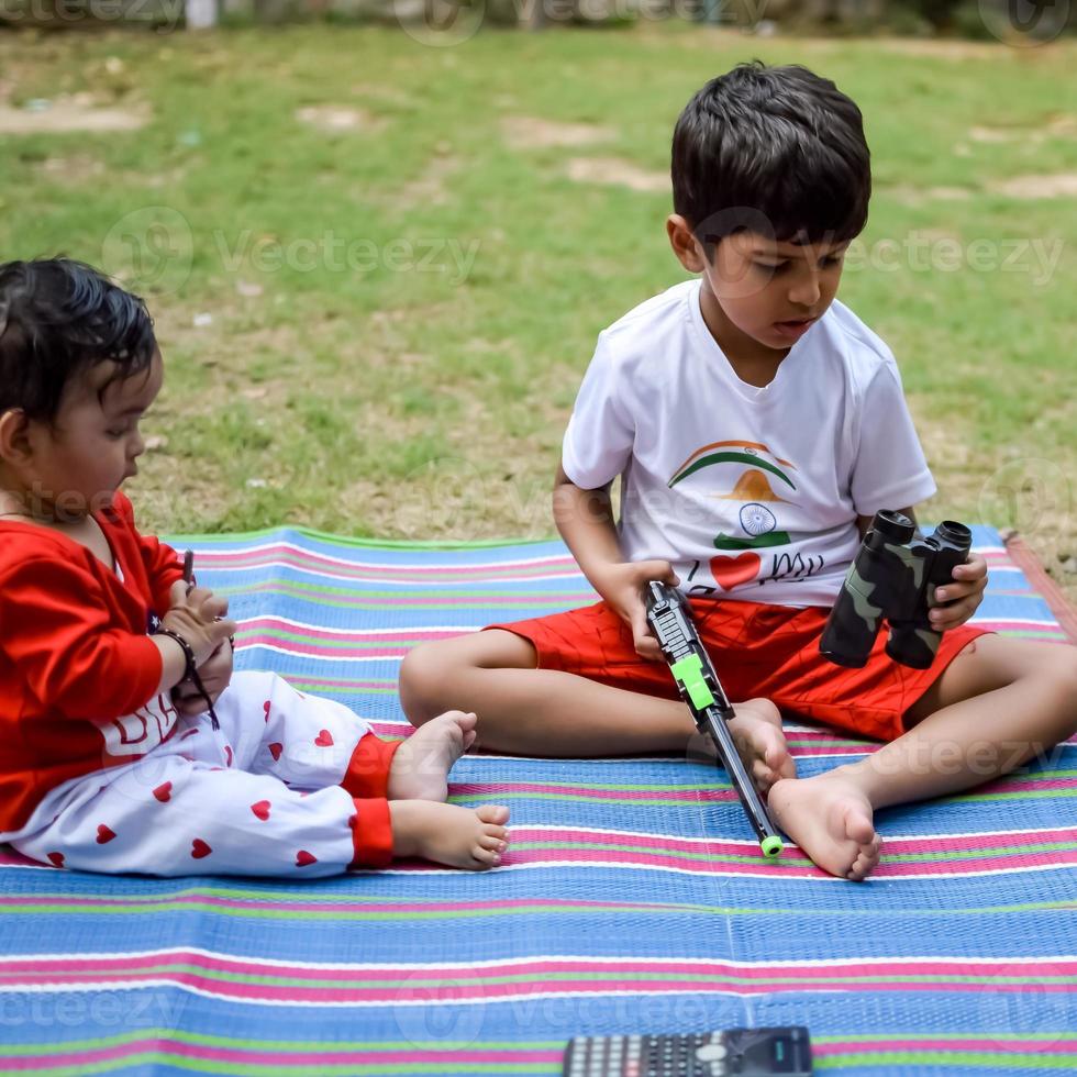 Two happy boys in society park, happy Asian brothers who are smiling happily together. Brothers play outdoors in summer, best friends. Toddler baby boy playing with his happy brother in the garden photo