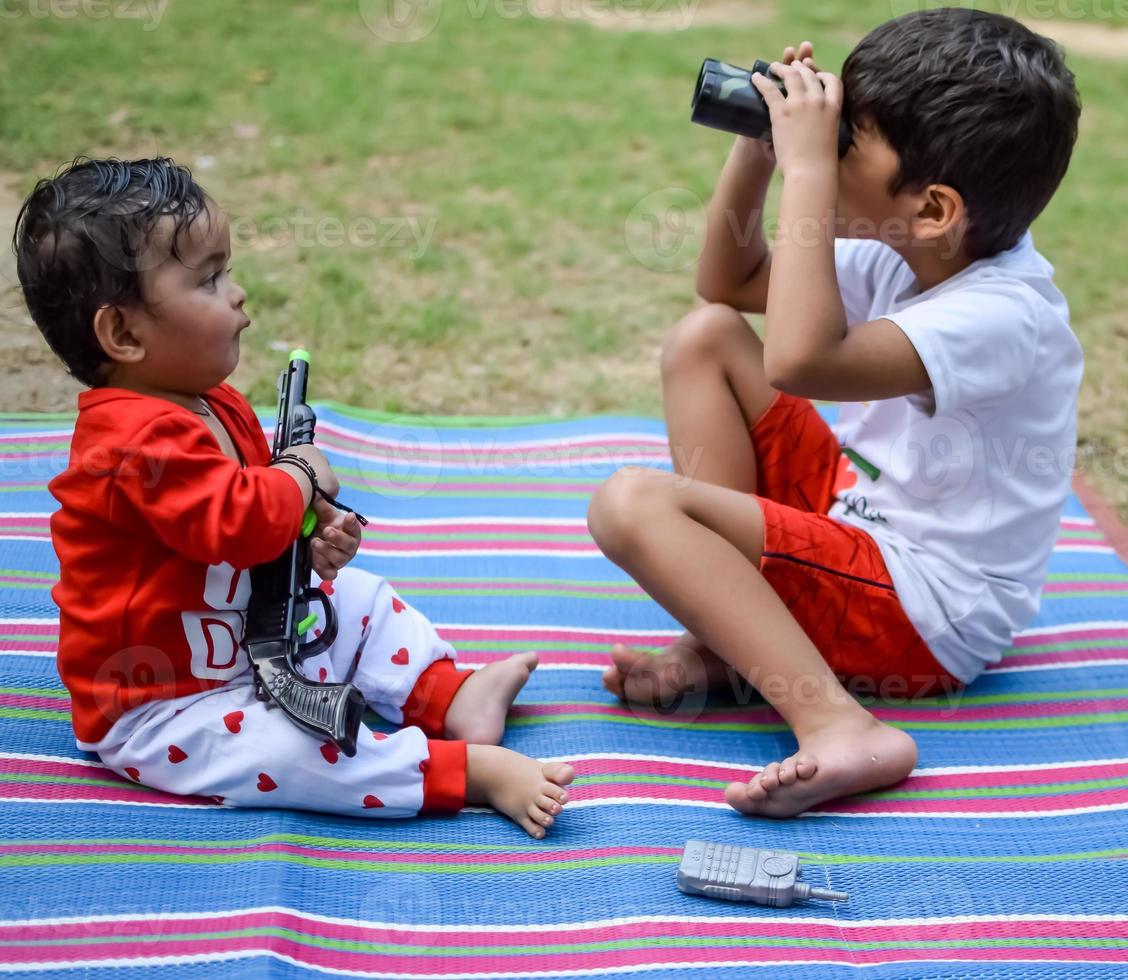 Two happy boys in society park, happy Asian brothers who are smiling happily together. Brothers play outdoors in summer, best friends. Toddler baby boy playing with his happy brother in the garden photo