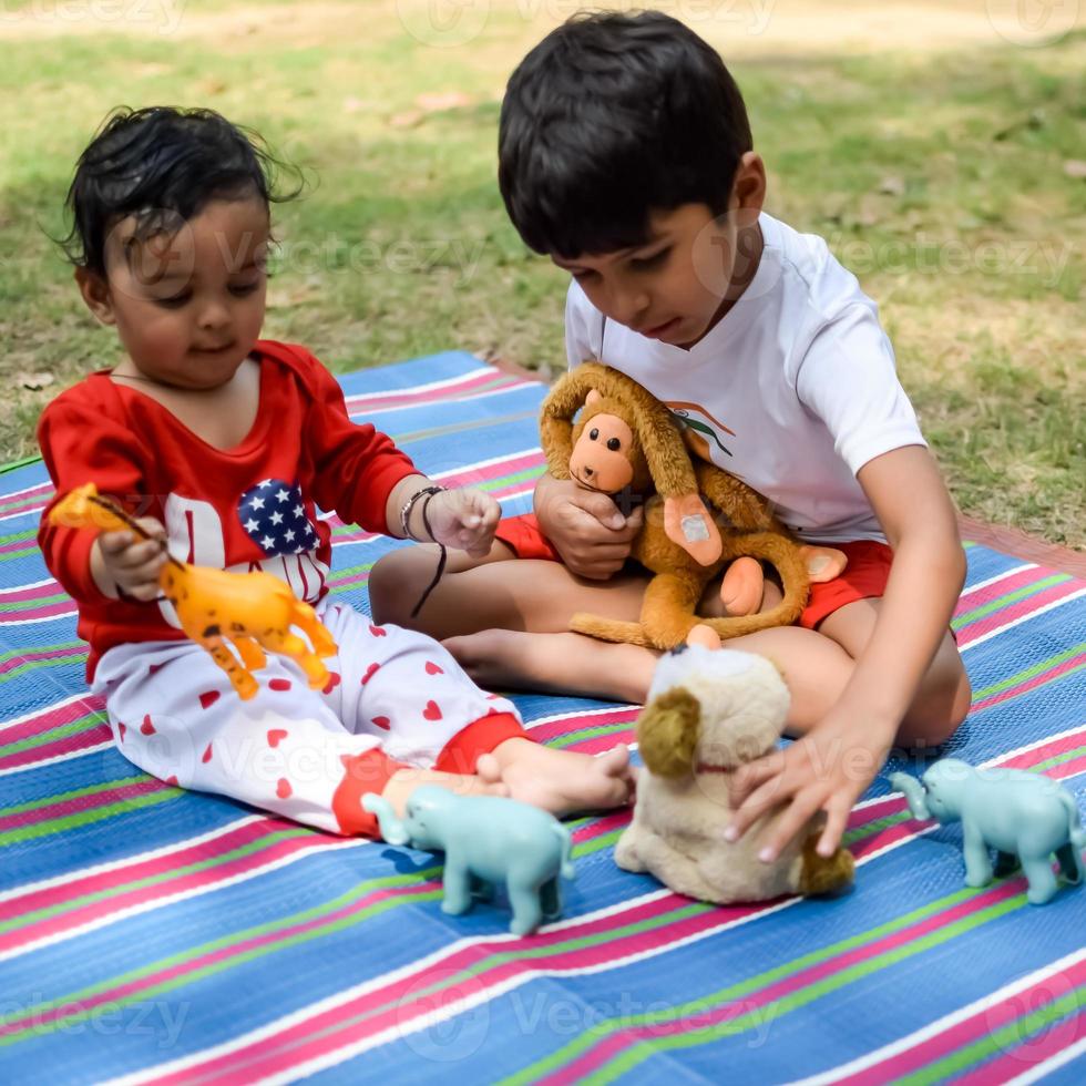 Two happy boys in society park, happy Asian brothers who are smiling happily together. Brothers play outdoors in summer, best friends. Toddler baby boy playing with his happy brother in the garden photo