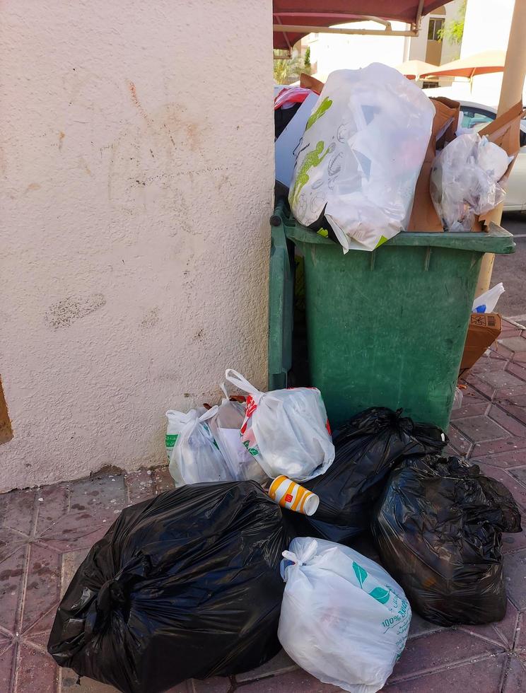 Overflowing trash can  in the street,trash garbage full,outdoor dustbin over photo