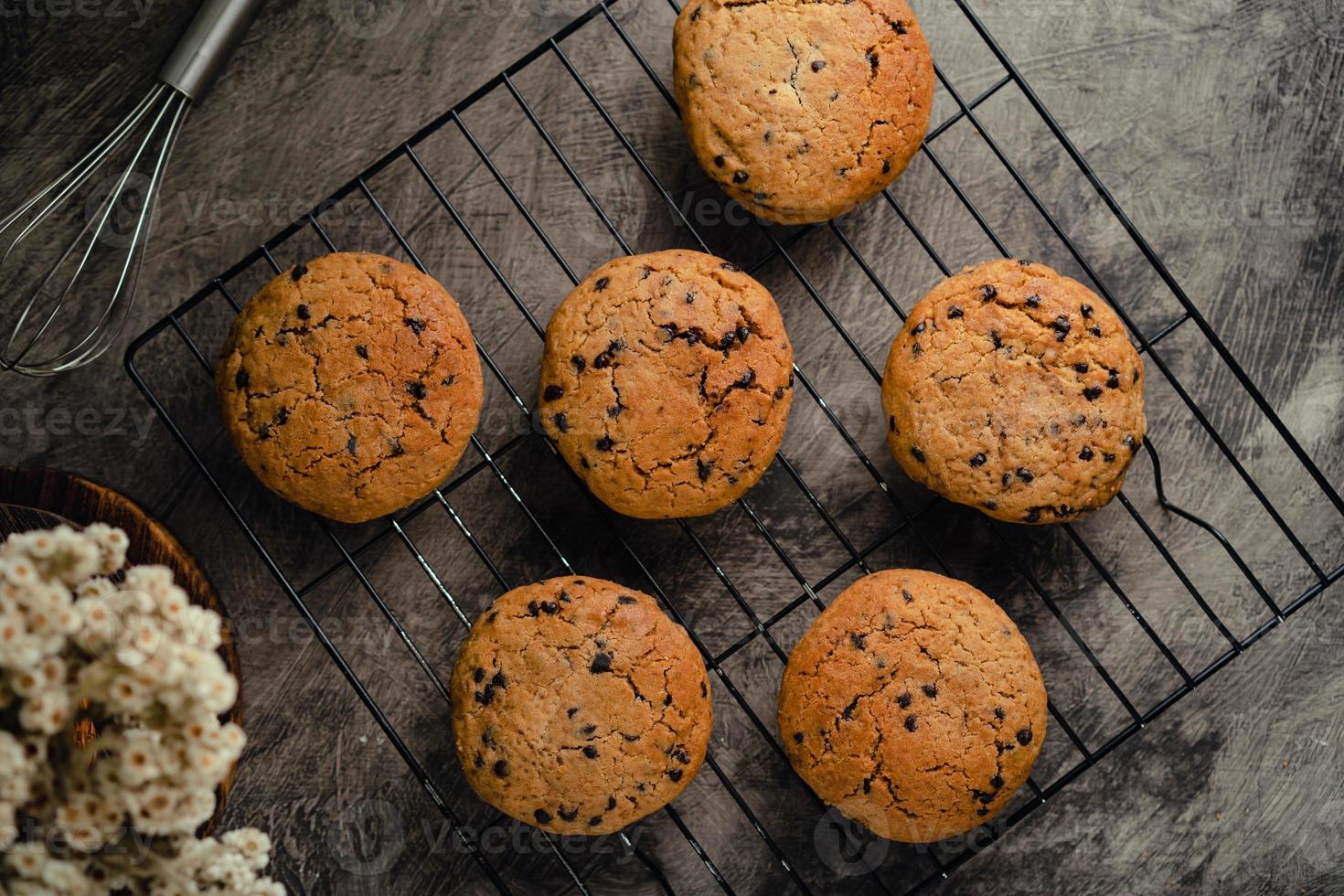 Homemade chocolate chip cookies on black baking cooling tray and abstract background photo