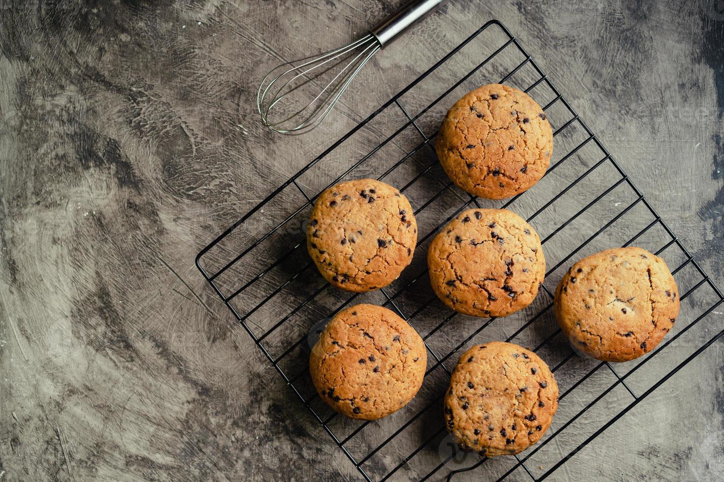 hecho en casa chocolate chip galletas en negro horneando enfriamiento bandeja y resumen antecedentes foto