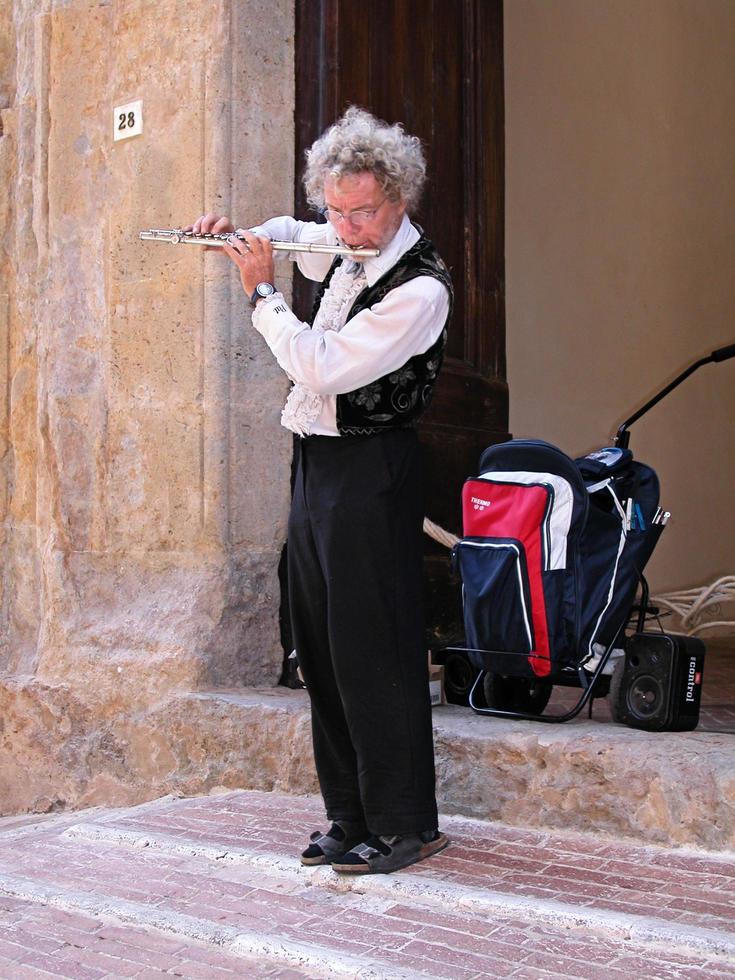 Bologna, Italy, April 16, 2015 Street performer playing flute. Busking on street concept. photo