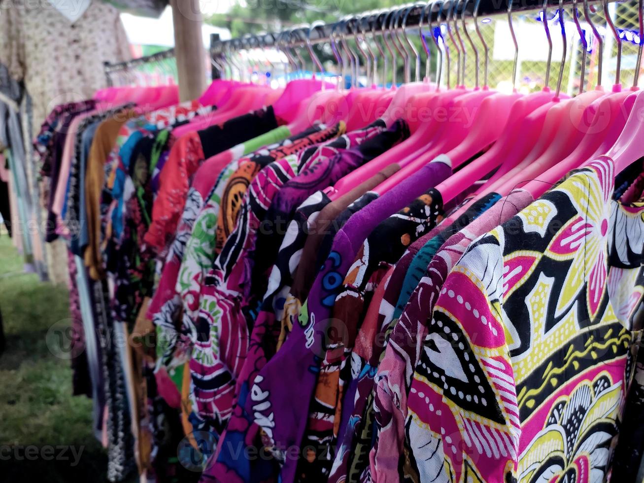 Colorful women's batik cloth hanging on a hanger in a traditional market. photo