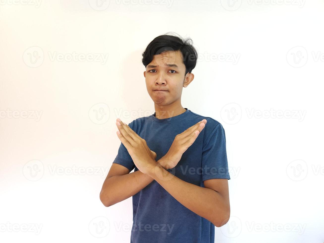 Man crossed his arms as disapproval and rejection gesture on isolated white background photo