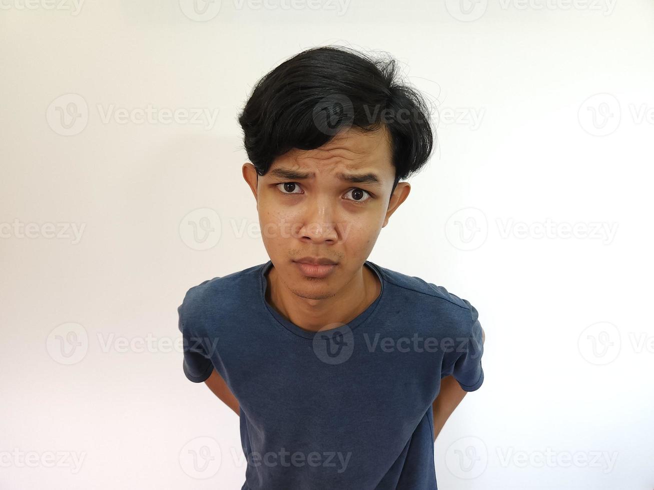 Funny obvious peeking Asian man in grey t-shirt isolated on white background photo