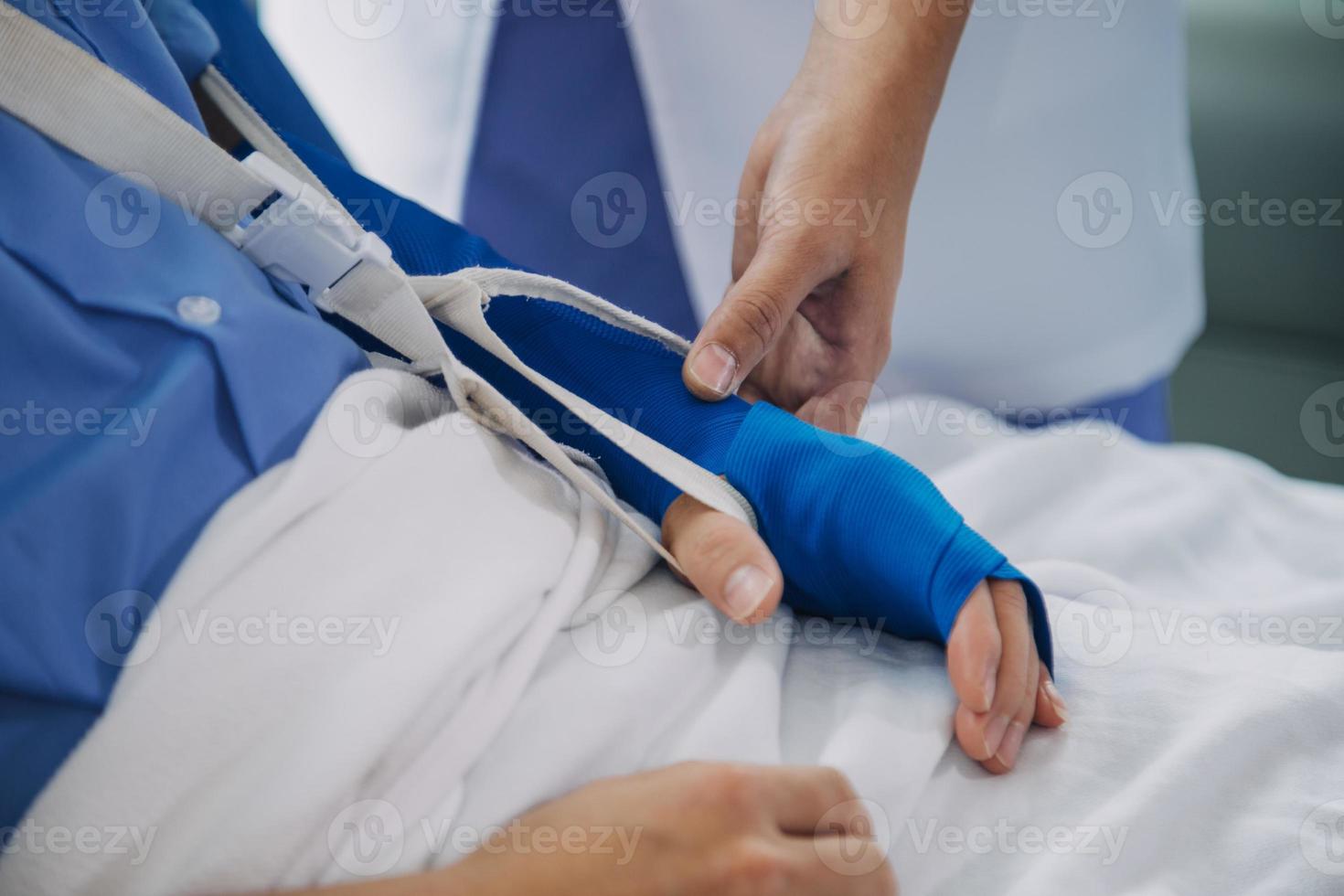 Injured patient showing doctor broken wrist and arm with bandage in hospital office or emergency room. Sprain, stress fracture or repetitive strain injury in hand. Nurse helping customer. First aid. photo