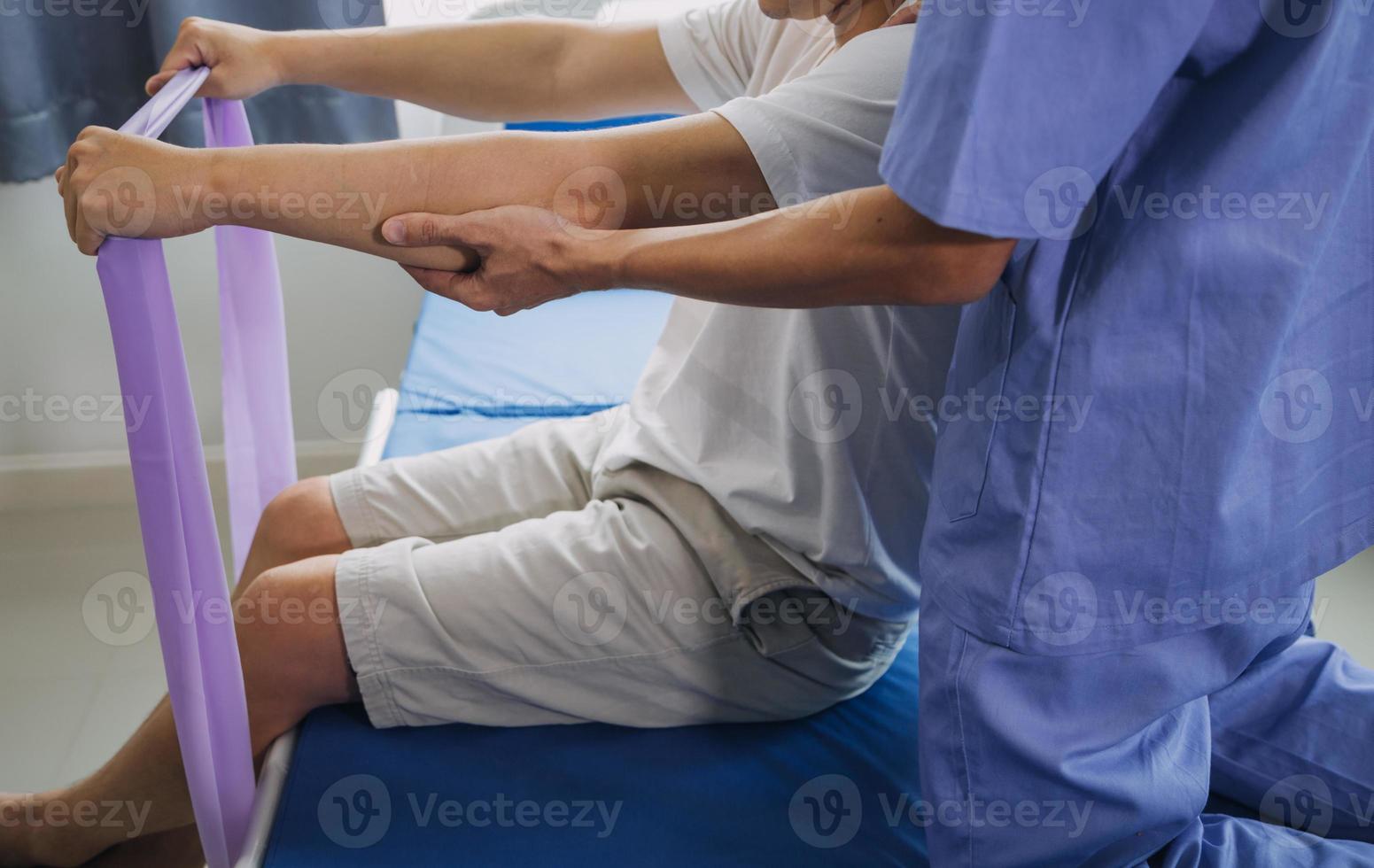 Doctor or Physiotherapist working examining treating injured arm of athlete male patient, stretching and exercise, Doing the Rehabilitation therapy pain in clinic. photo
