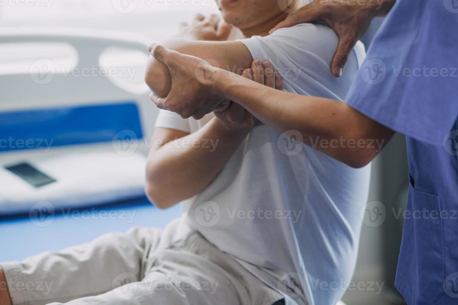 Doctor or Physiotherapist working examining treating injured arm of athlete male patient, stretching and exercise, Doing the Rehabilitation therapy pain in clinic. photo