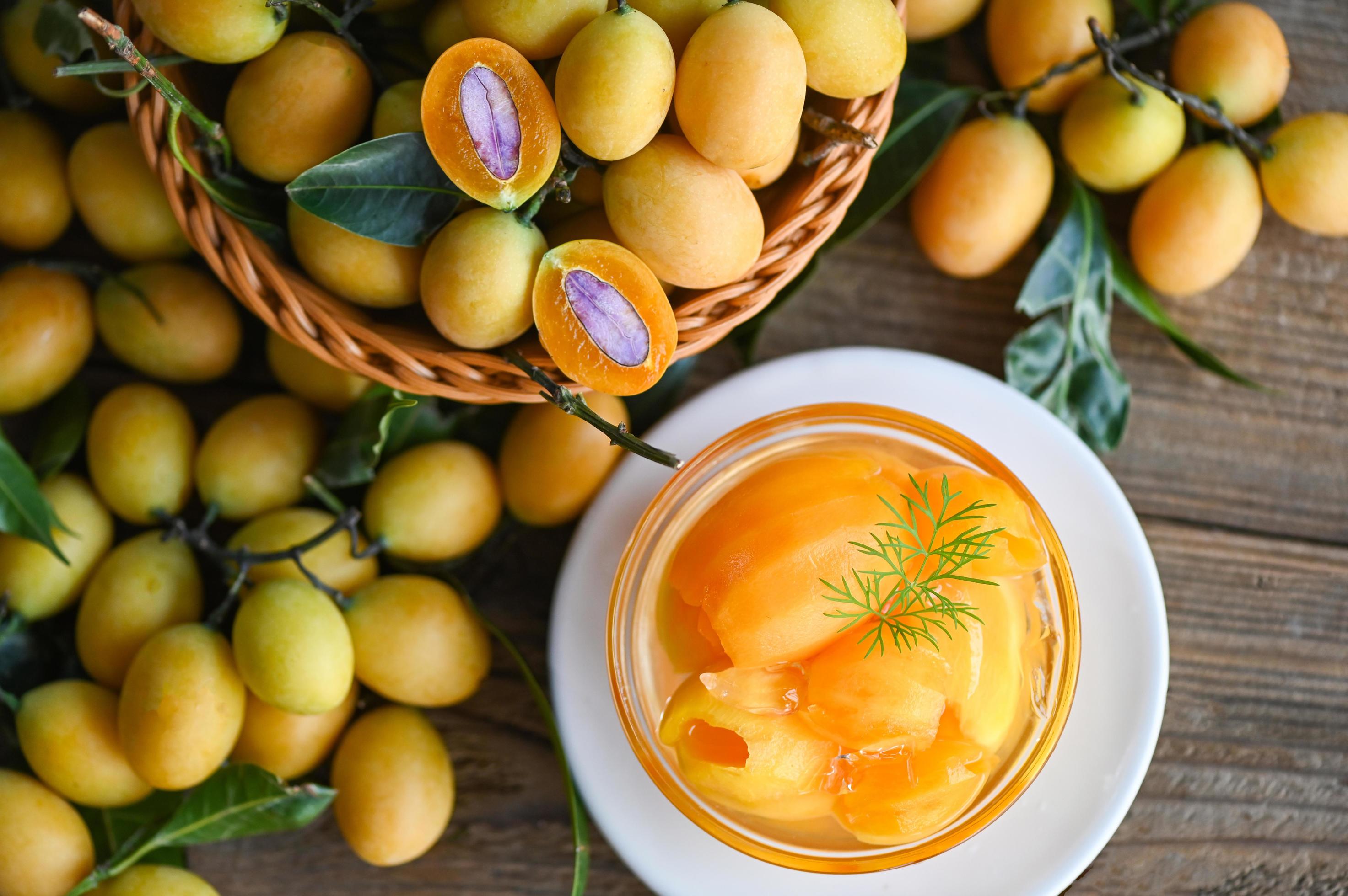 sweet-dessert-marian-plum-fruit-on-bowl-for-food-and-wooden-background