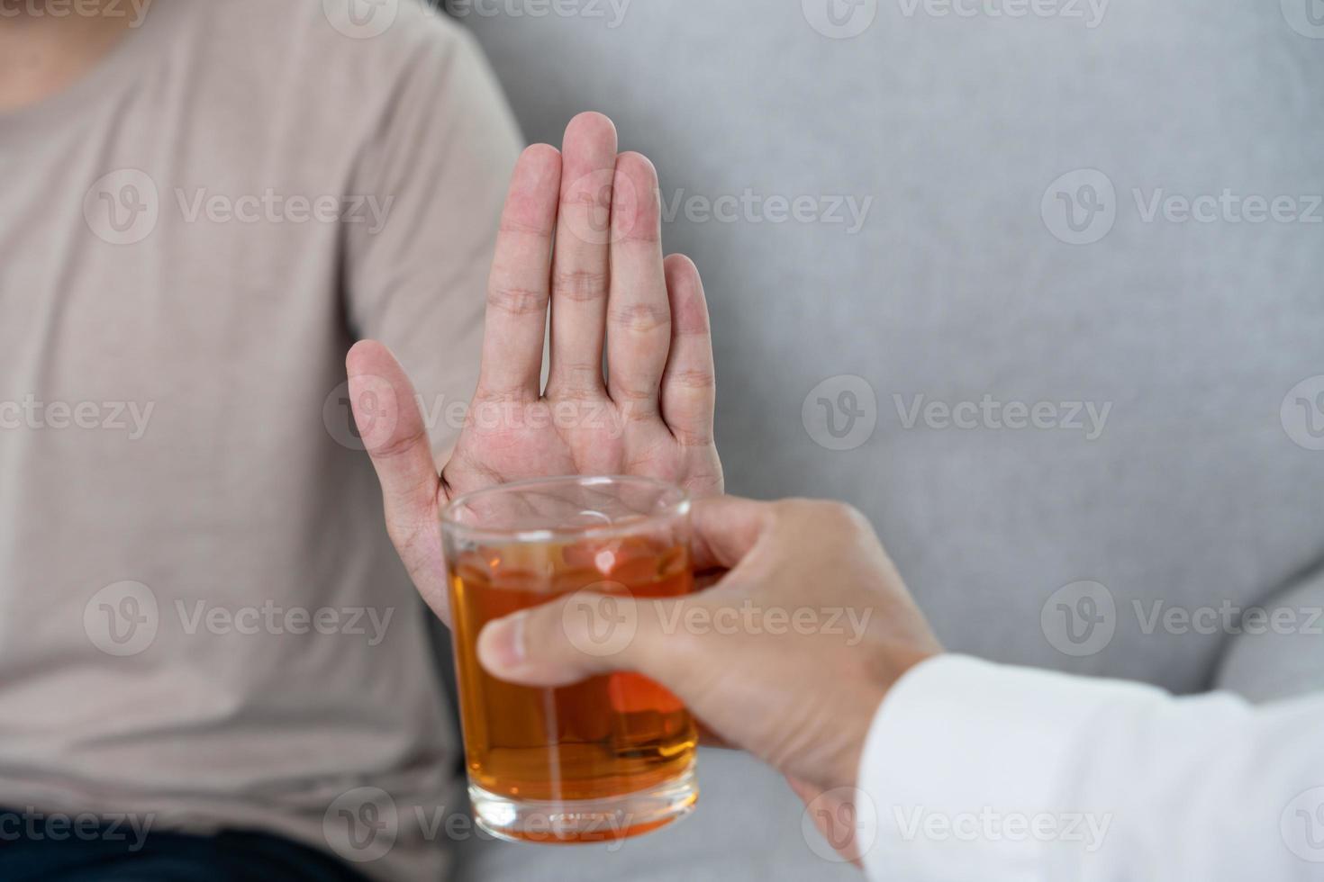 hombre se niega decir No y evitar a bebida un alcohol whisky , parada mano firmar masculino, alcoholismo tratamiento, alcohol adiccion, dejar bebida alcohólica, detener Bebiendo alcohol. negar vaso espíritu, insalubre, rechazar foto