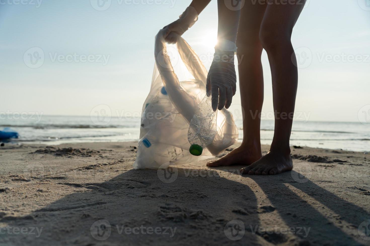Save water. Volunteer pick up trash garbage at the beach and plastic bottles are difficult decompose prevent harm aquatic life. Earth, Environment, Greening planet, reduce global warming, Save world photo