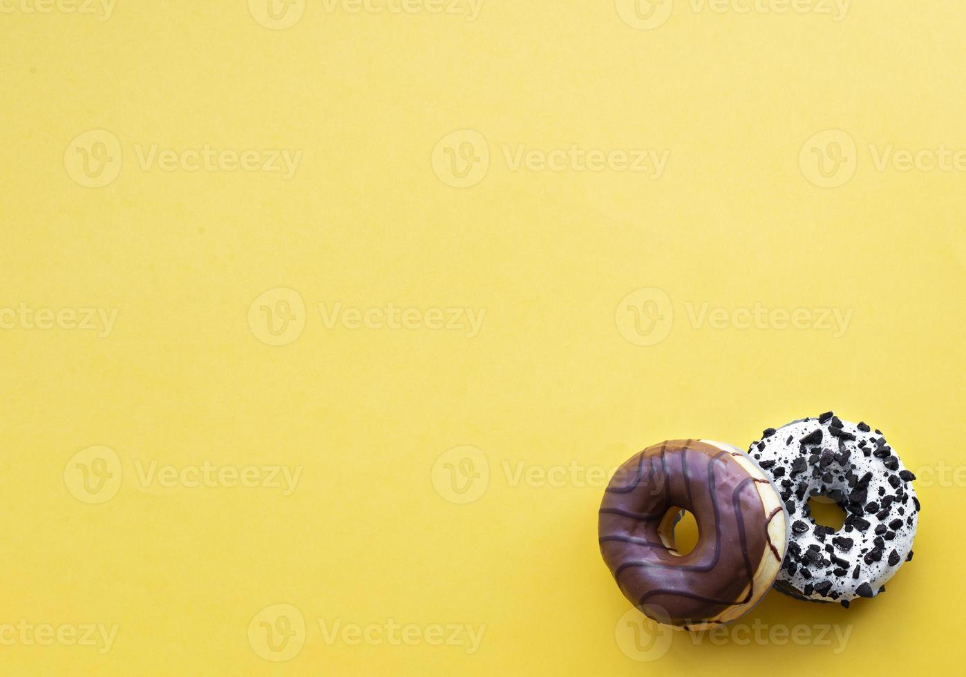 Donuts with chocolate drops on a yellow background. Place for inscriptions. photo