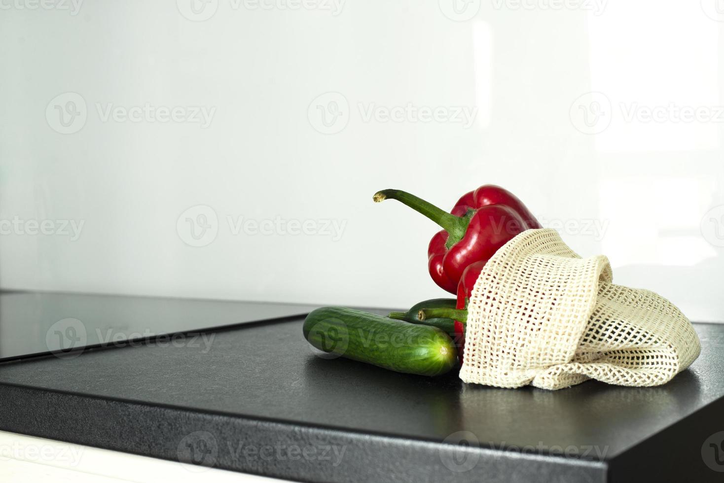 Vegetables in a grid on the kitchen table. Bulgarian pepper and cucumbers. Grid for vegetables. photo