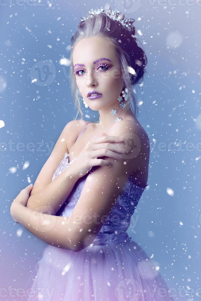 Girl model in the image of the snow queen on a background of snow .Winter girl. photo