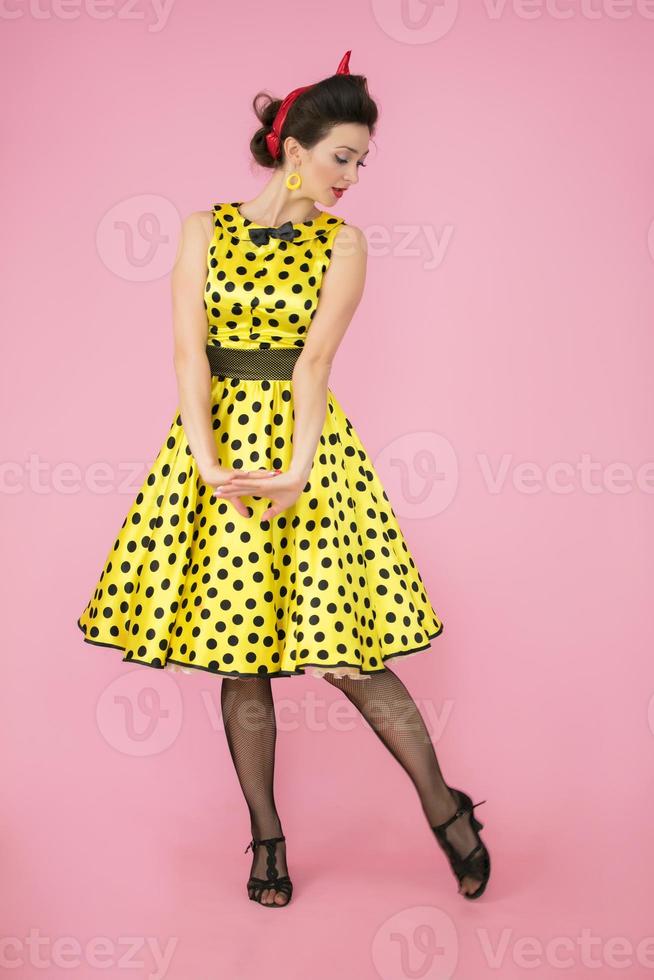 Retro girl. Fifties style woman on pink background. photo