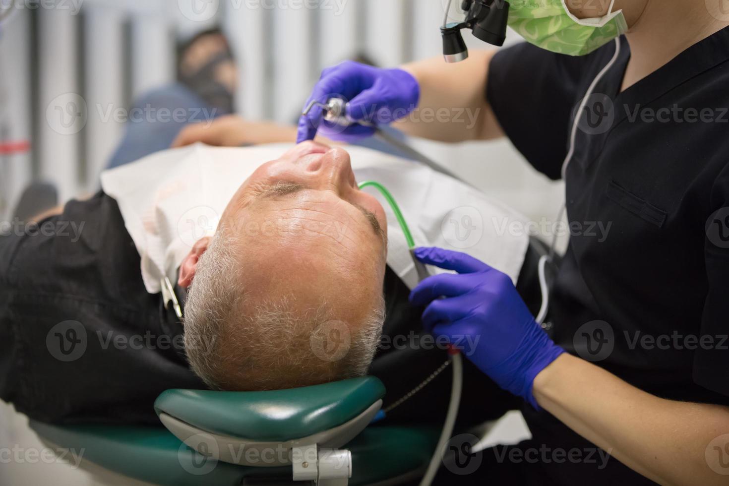 Dental office. The hands of the dentist treats the teeth of the patient. photo