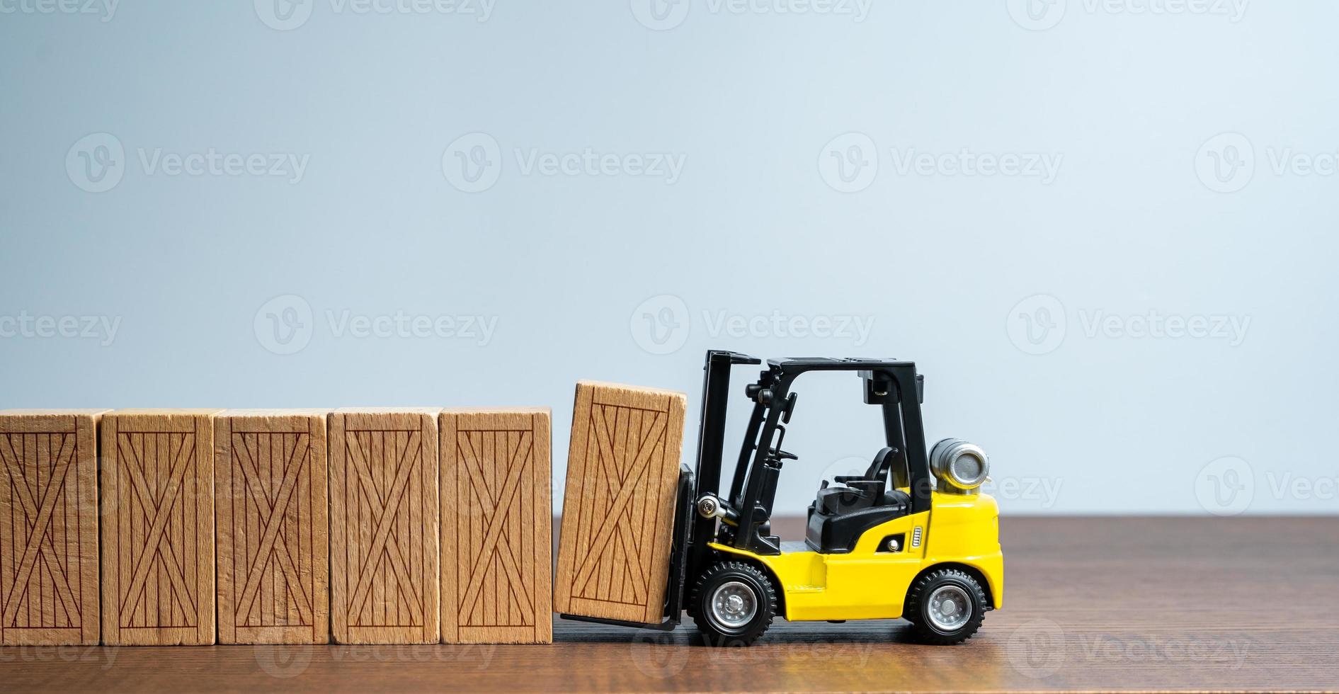 A forklift makes a fence wall out of wooden boxes. Mass production. Delivery of parcels and orders. Trading traffic. Transportation and transfer. Logistics. Delivery of oversized cargo. photo