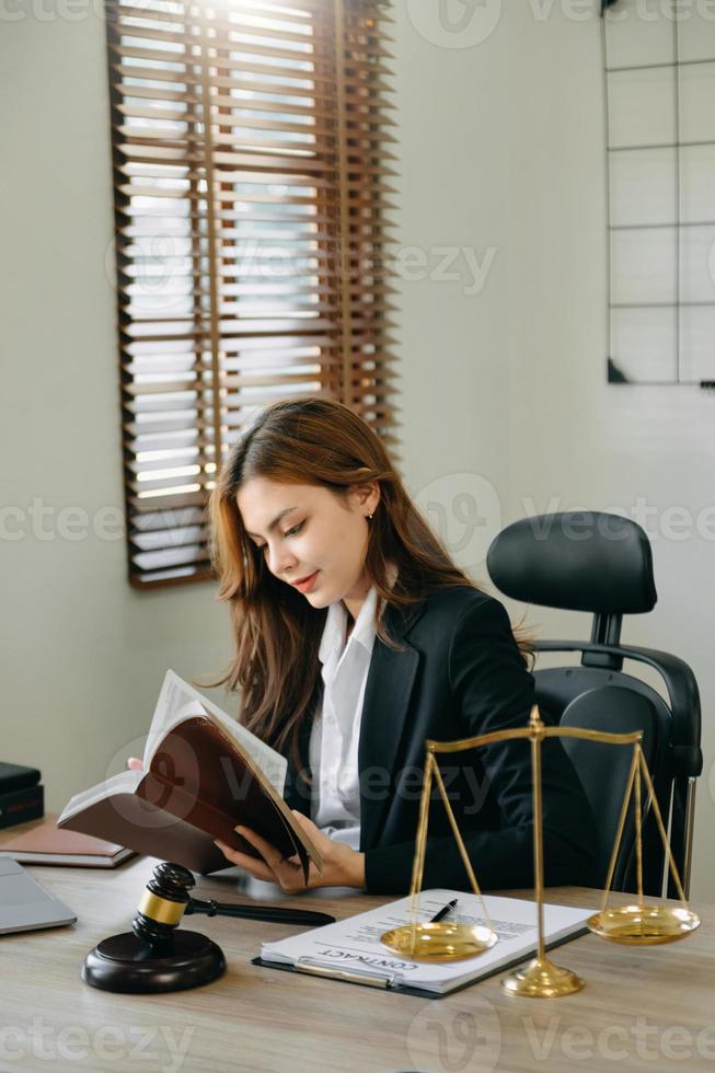 mujer abogado leyendo legal libro con mazo en mesa en oficina. justicia y ley ,abogado concepto. foto