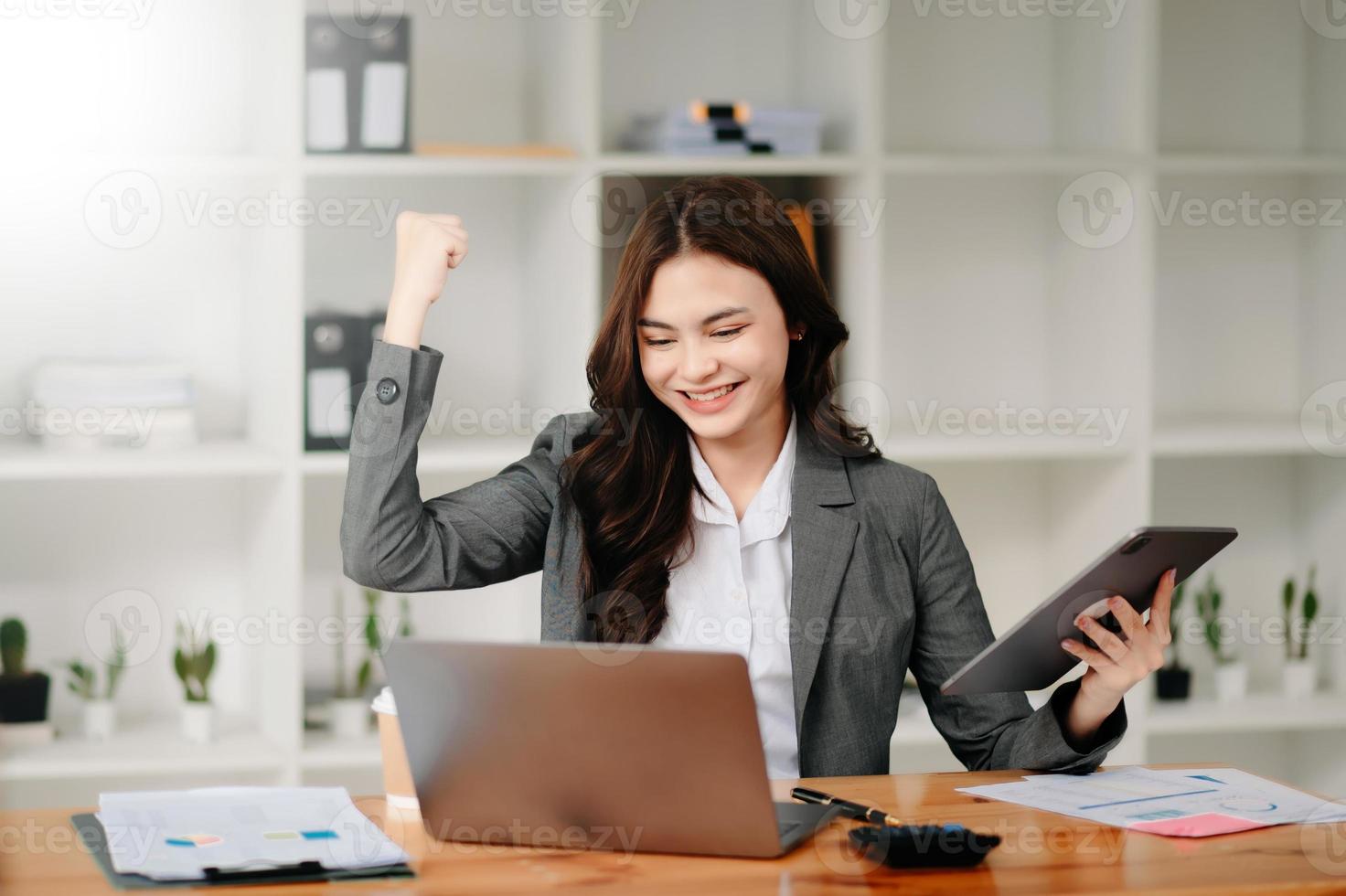 las mujeres de negocios están encantadas y felices con el trabajo que hacen en su tableta, computadora portátil y tomando notas en la oficina moderna. foto