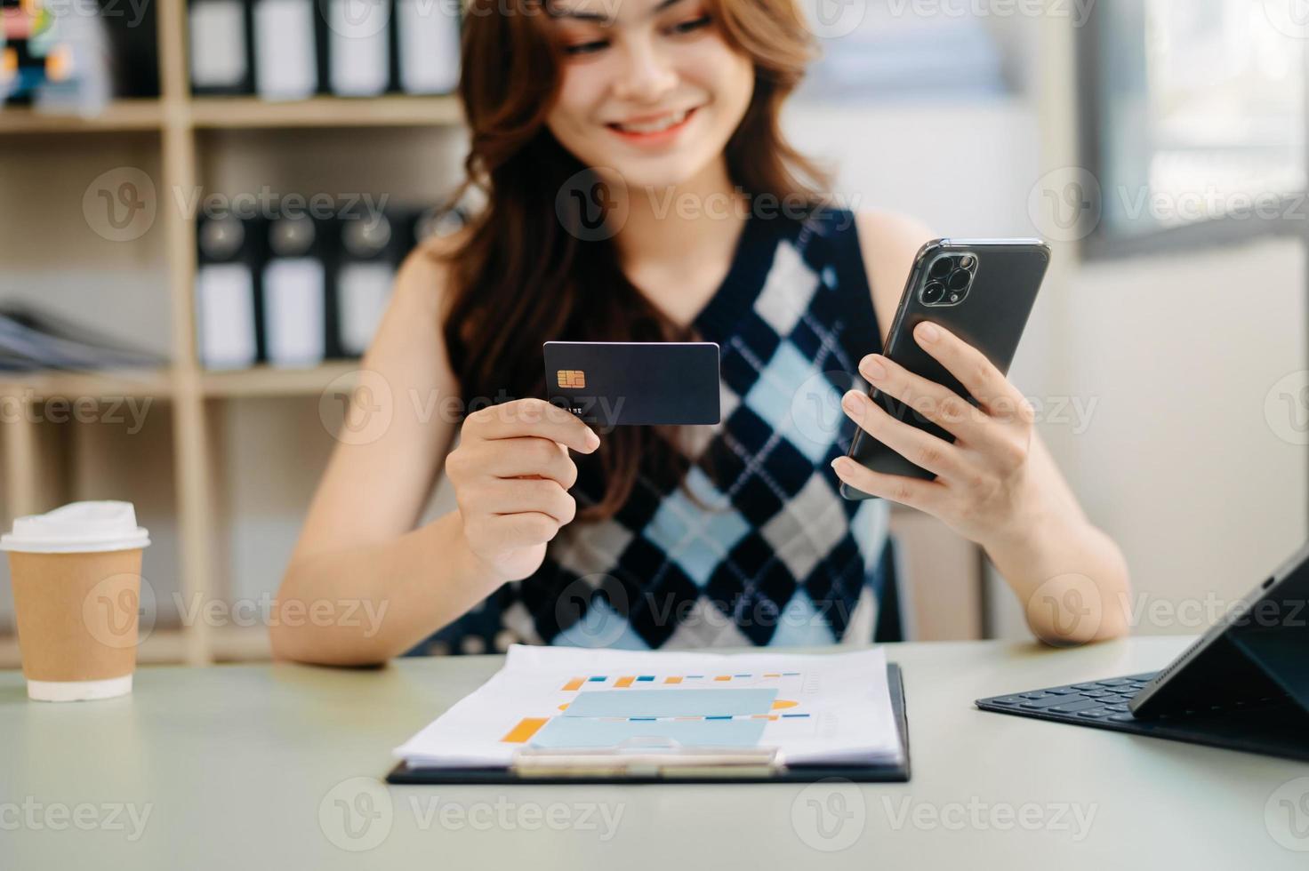 mano de mujer de negocios usando teléfonos inteligentes, pagos de tabletas y compras en línea con tarjeta de crédito, omnicanal, computadora de teclado de acoplamiento de tableta digital en la oficina foto