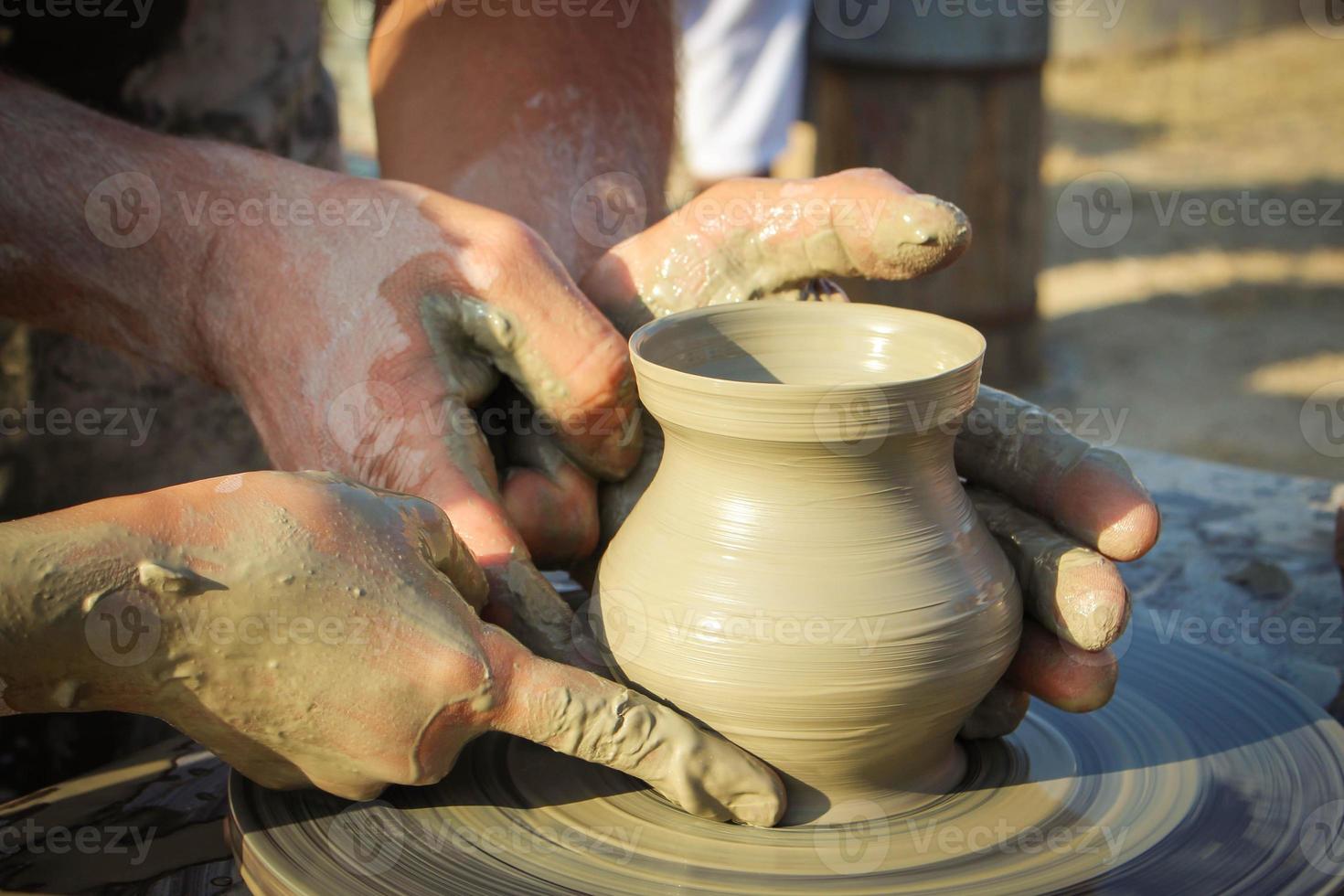 potter helps the child to make a vase from clay photo