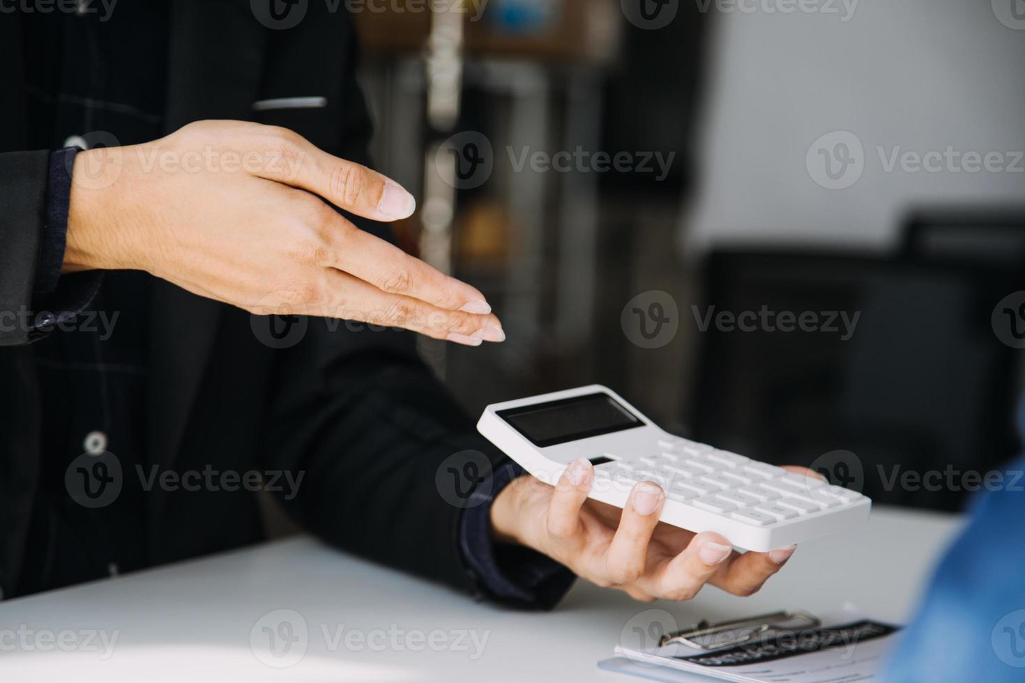 Closeup of Asian female signing car insurance document or lease paper contract or agreement. Buying or selling new or used vehicle with car keys on table. photo
