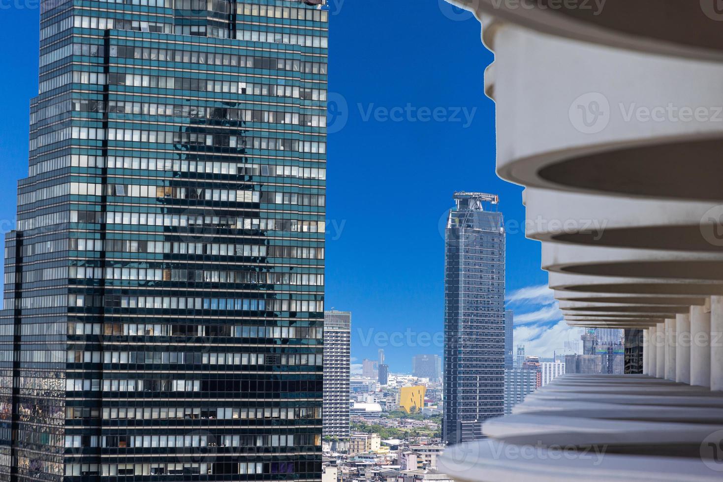 View of high-rise facades through a structure from balconies during the day photo