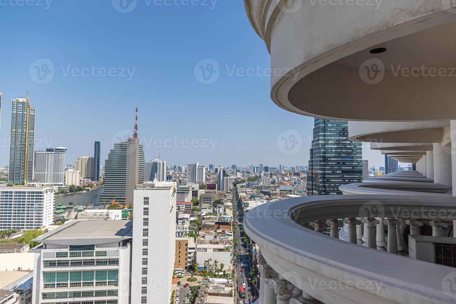 View of high-rise facades through a structure from balconies during the day photo