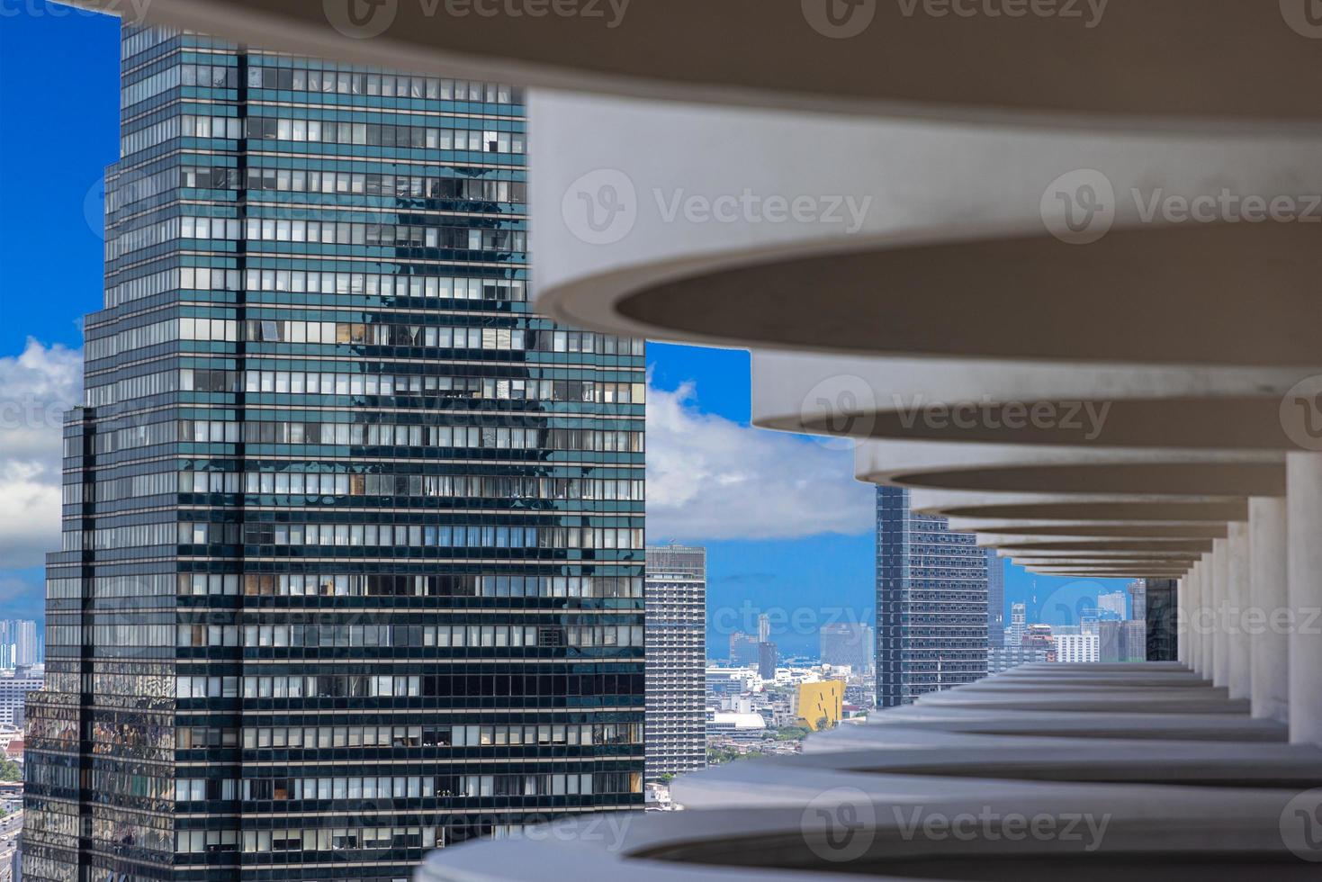 View of high-rise facades through a structure from balconies during the day photo