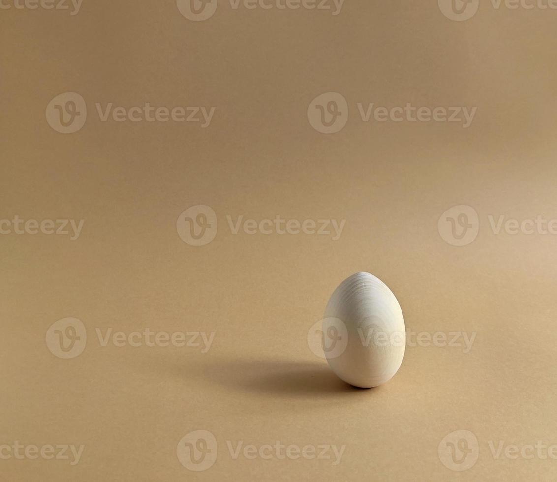 Wooden easter egg for painting on a pastel background. Scene with geometrical forms. Copy space photo