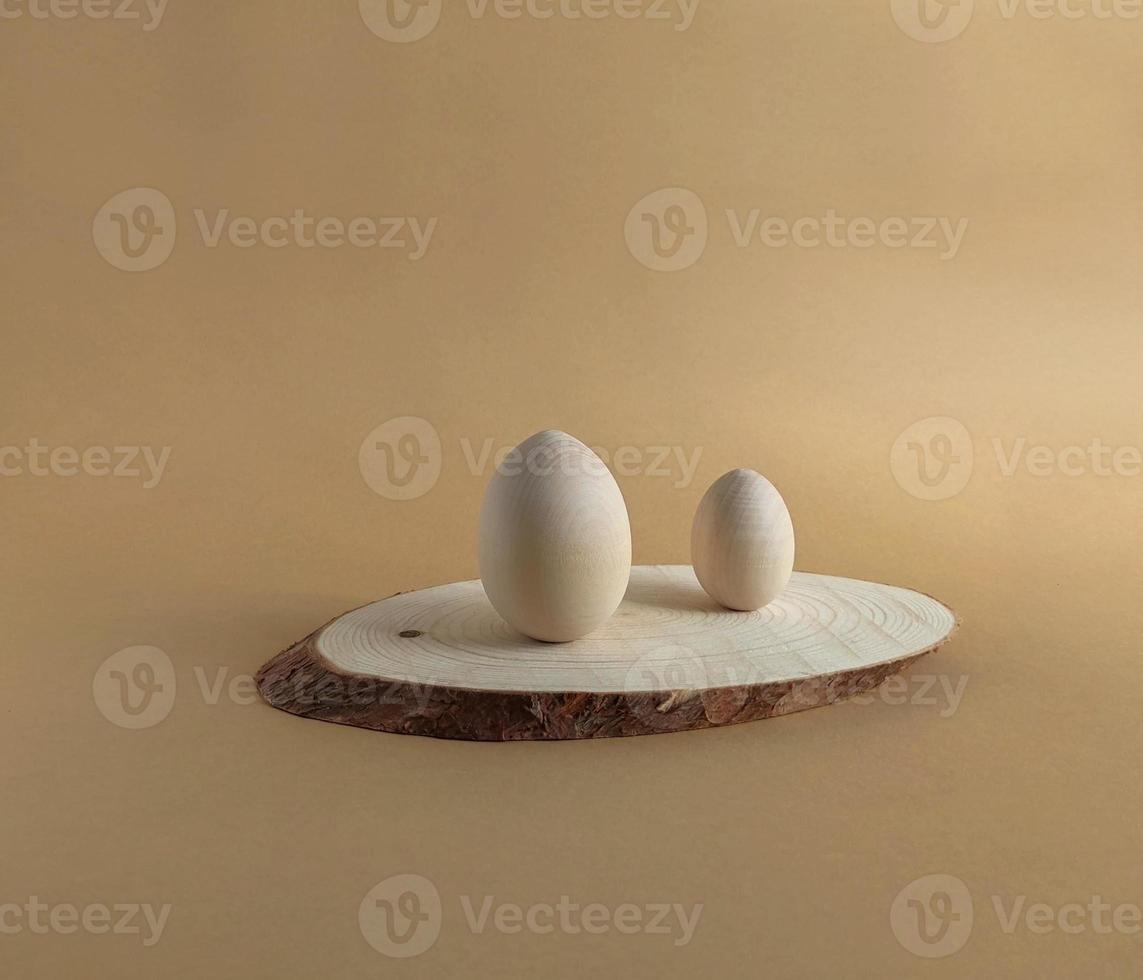 Wooden easter egg for painting on a wooden podium on a pastel background. Scene with geometrical forms. Copy space. photo