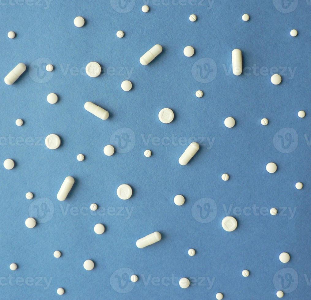 Pattern with white pills and capsules on blue background. Treatment and of hope for recovery. Minimal concept template for online pharmacy. photo