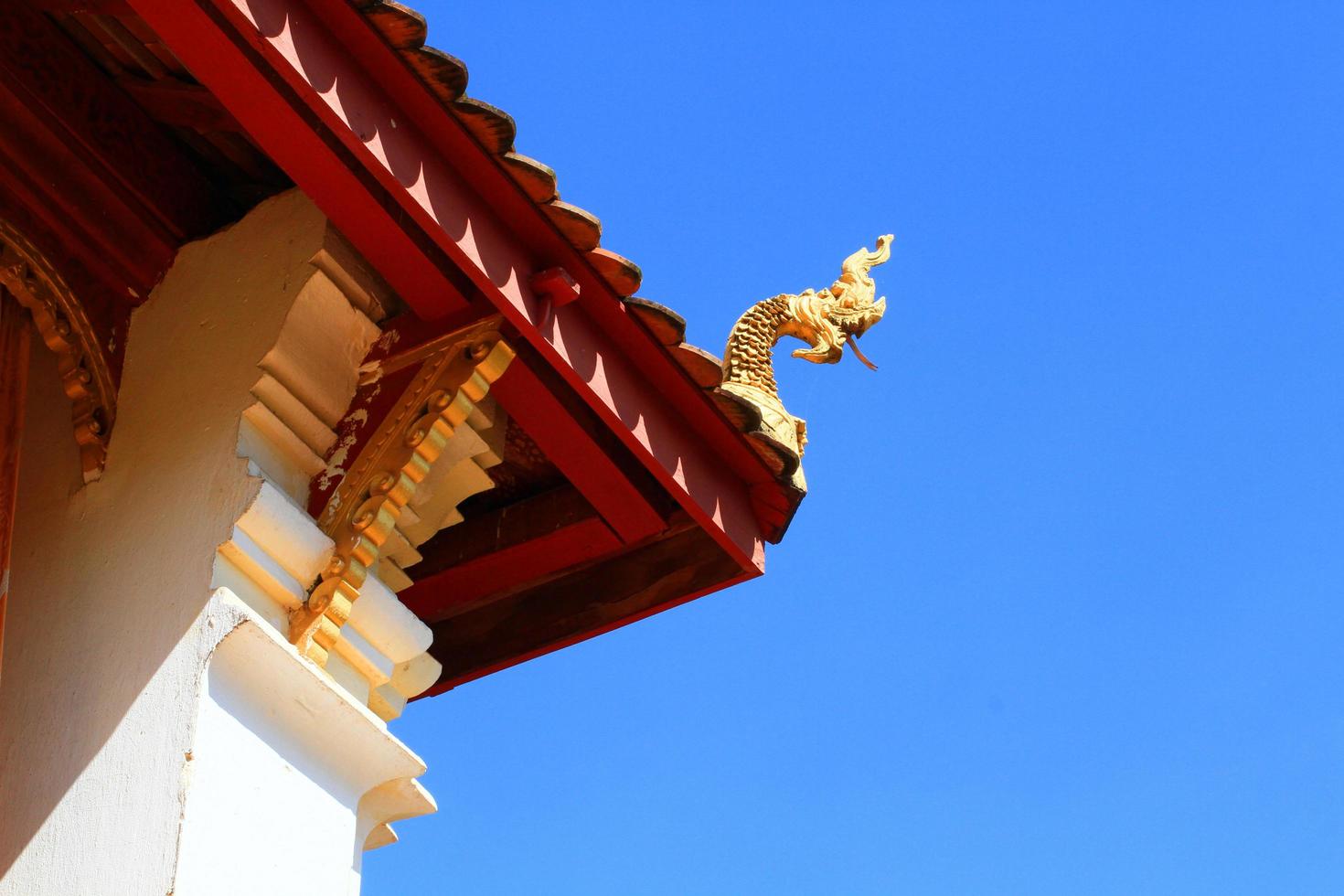 Golden naga on Art Roof of Buddhist temple in blue sky photo