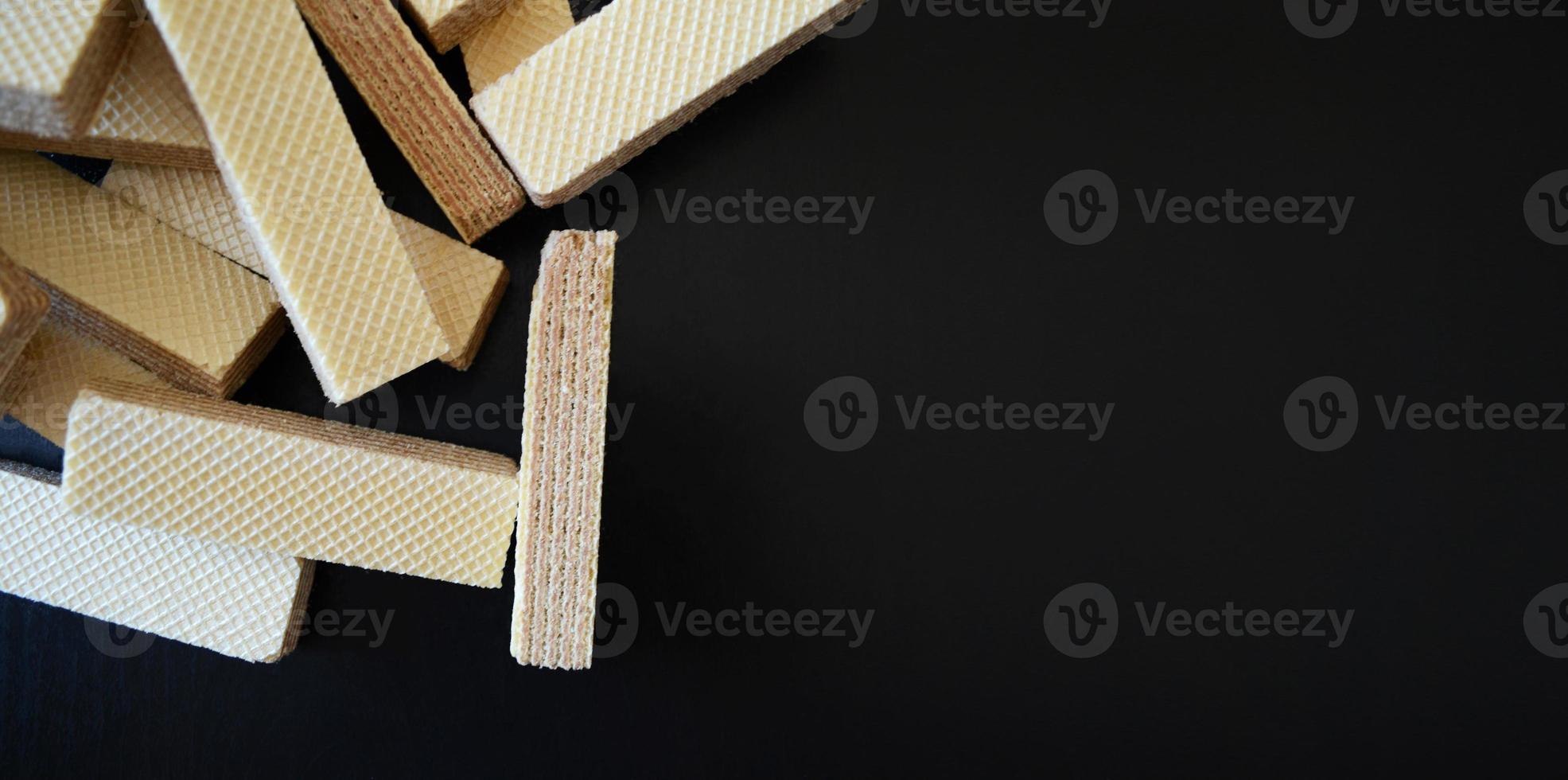 waffles on a dark background on the left, striped waffles, waffles and crumbs on the table, belgian waffles photo