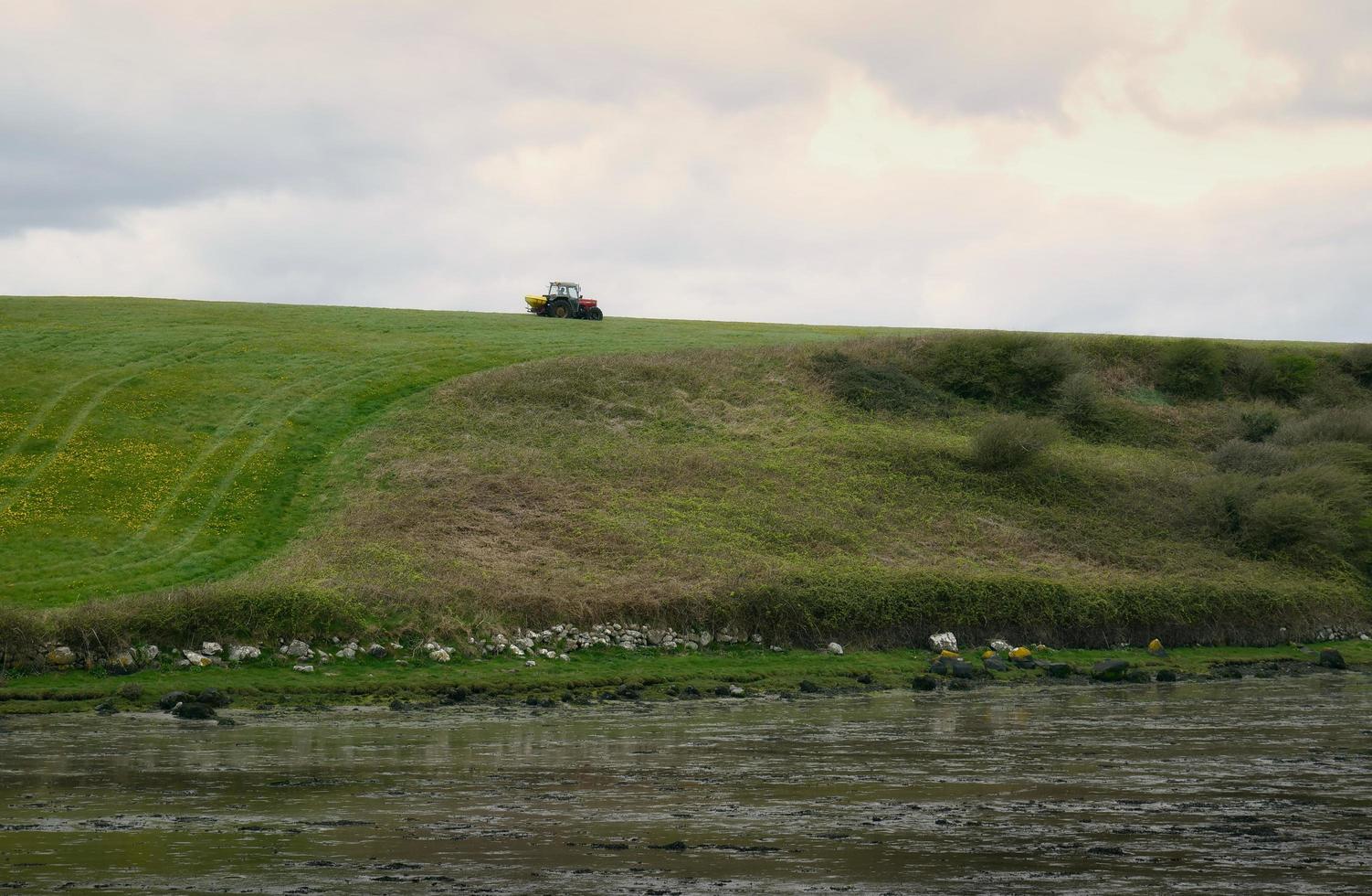 tractor conducción en granja en flor campo por el hilo de plata playa en galway, Irlanda foto