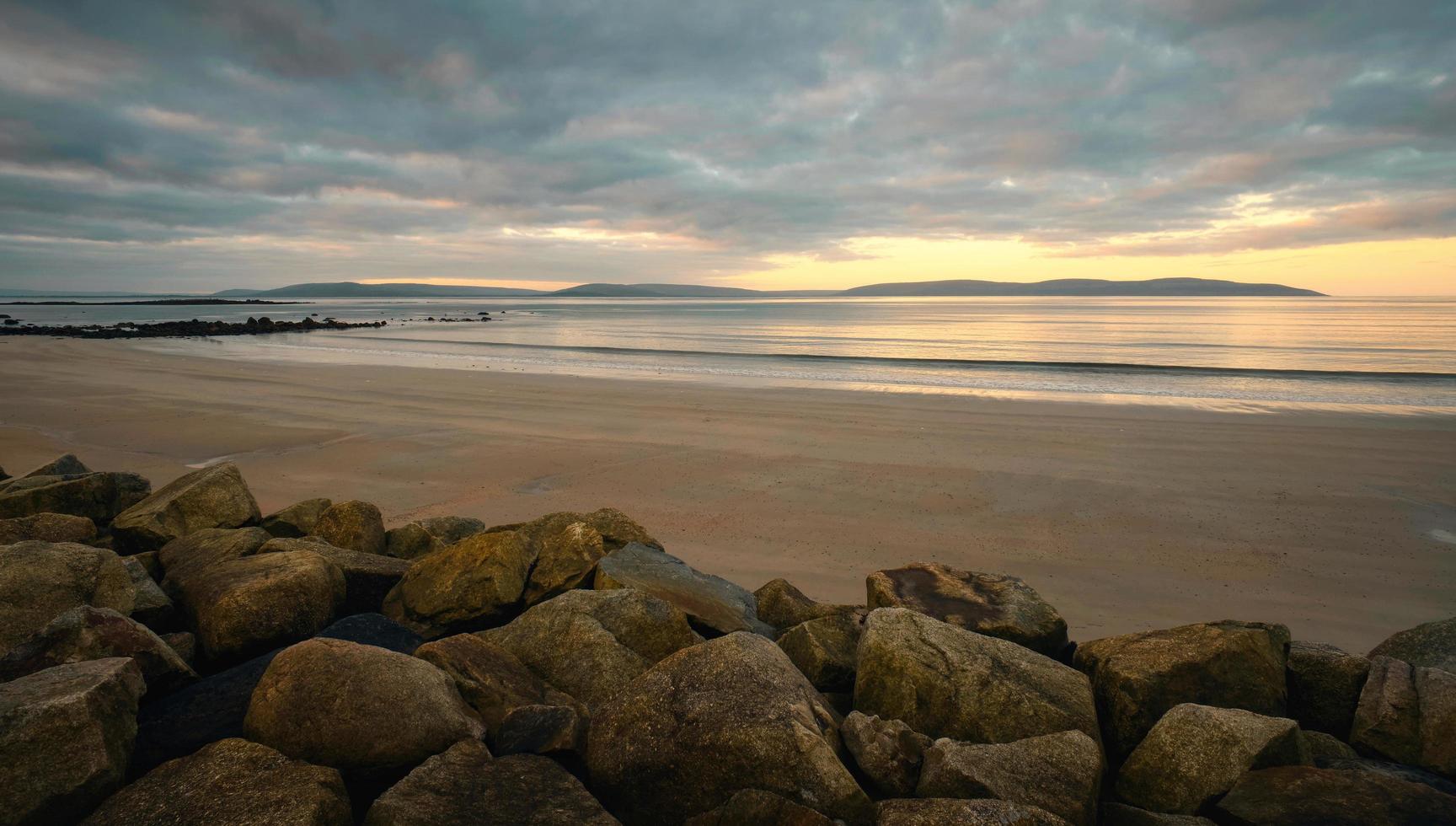hermosa costero amanecer paisaje paisaje de arenoso hilo de plata playa en galway, Irlanda foto
