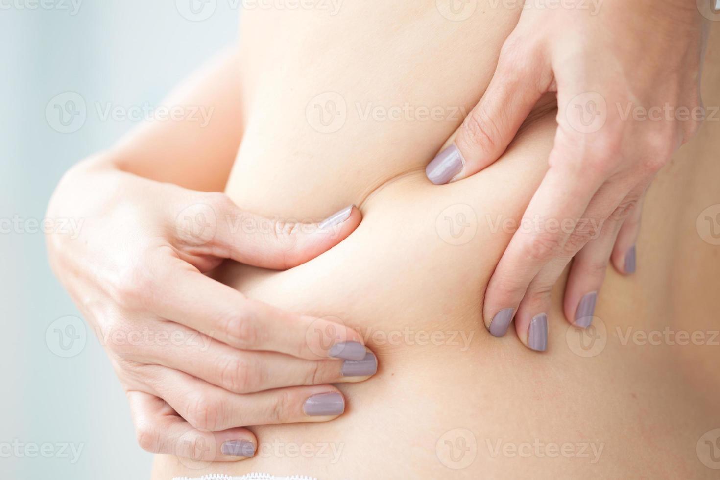 Young woman showing her localized fat in her back photo