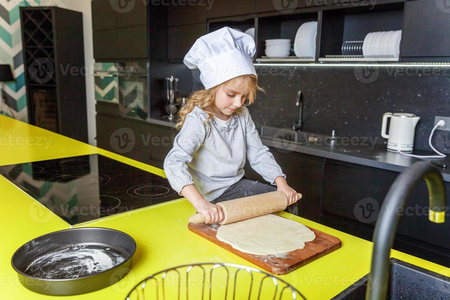 Little girl preparing dough, bake homemade holiday apple pie in kitchen photo