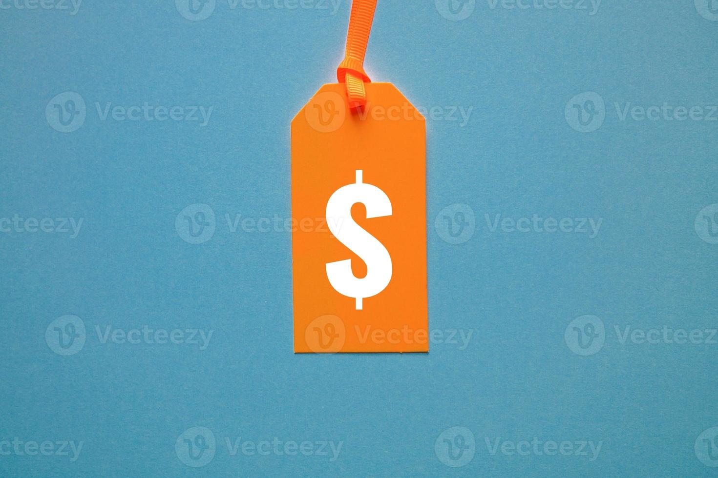 dollar symbol in orange price tag on blue background photo