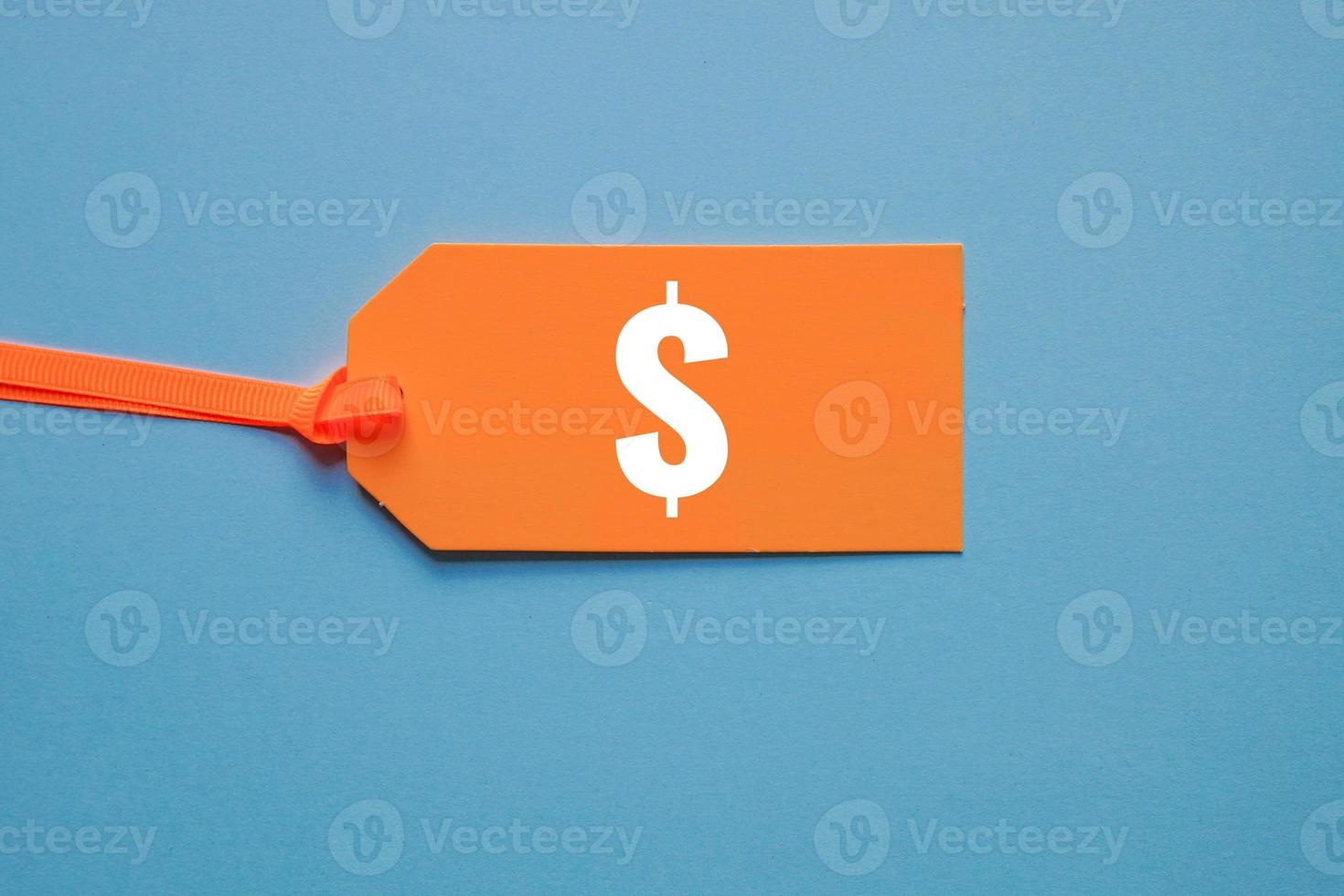 dollar symbol in orange price tag on blue background photo